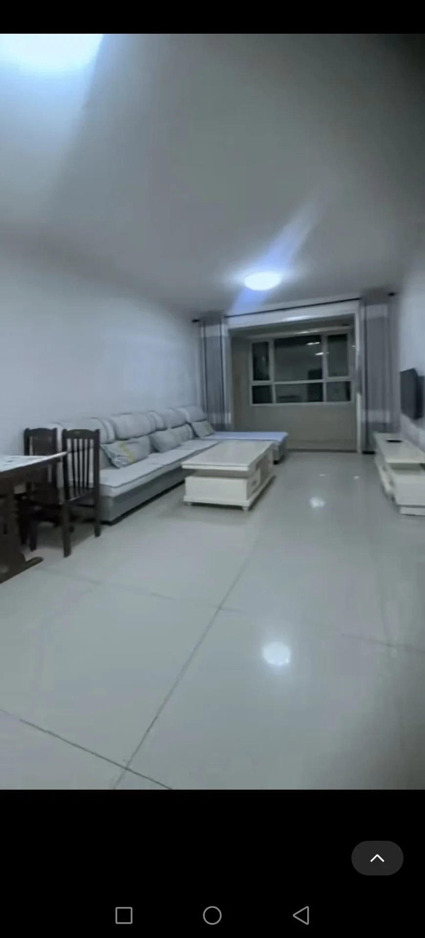 宽敞明亮的客厅，两侧各有一张沙发，中央摆放一把椅子，大窗户引入自然光，后墙挂有电视。关键字:客厅 沙发 椅子 自然光 电视