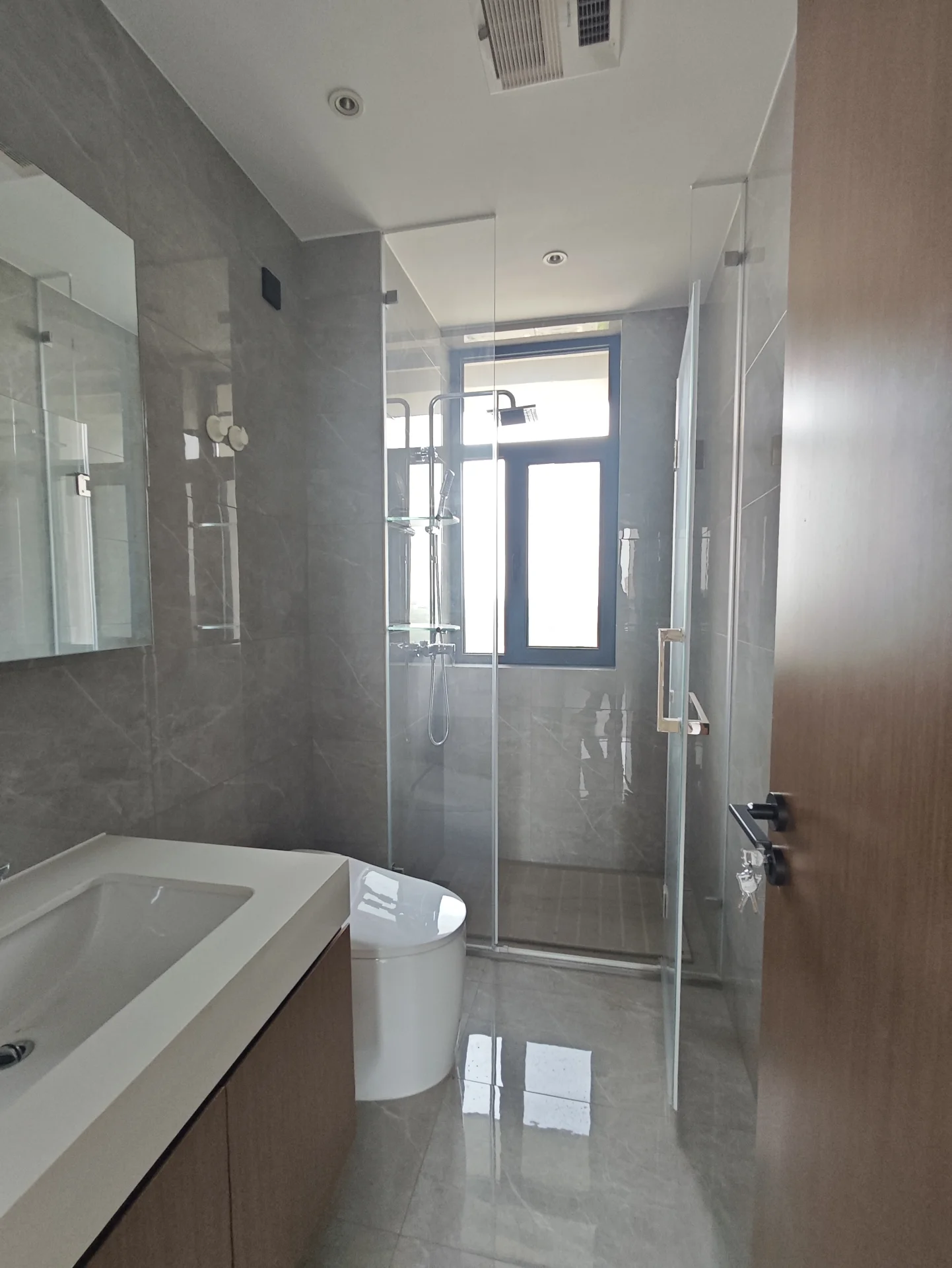 这是一间干净、现代的浴室，配有白色洁具和大窗户。浴室包括洗手盆、马桶、淋浴间和浴缸。房间内有镜子，整体显得井然有序，营造出宁静和清洁的氛围。大窗户带来了自然光，使空间更加明亮和宽敞。关键字:现代浴室 白色洁具 大窗户 自然光 宁静氛围