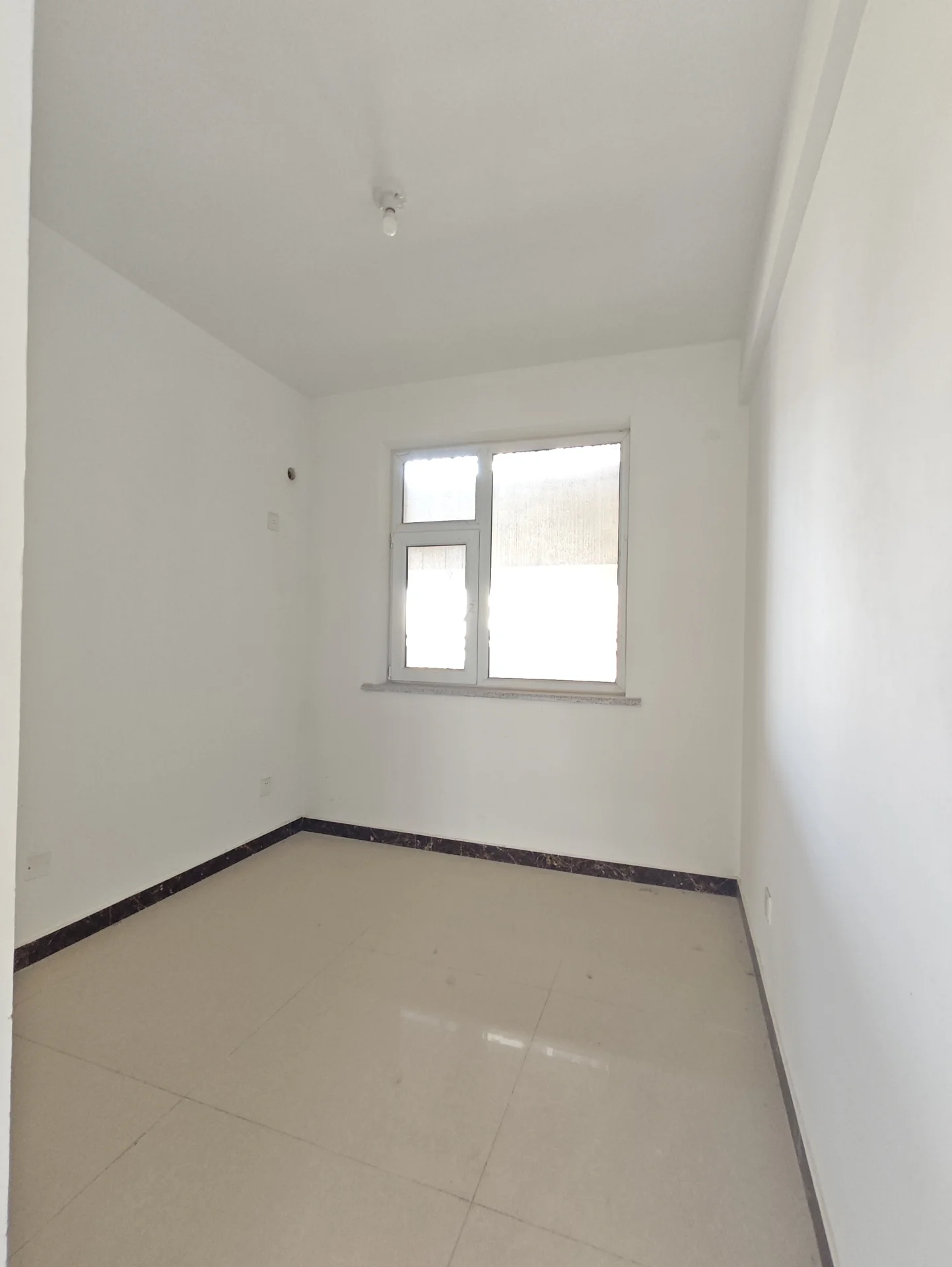 宽敞明亮的房间，白墙白地，一尘不染。自然光从窗户洒入，营造出宁静而清新的氛围。关键字:宽敞 明亮 白墙 白地 自然光 宁静 清新