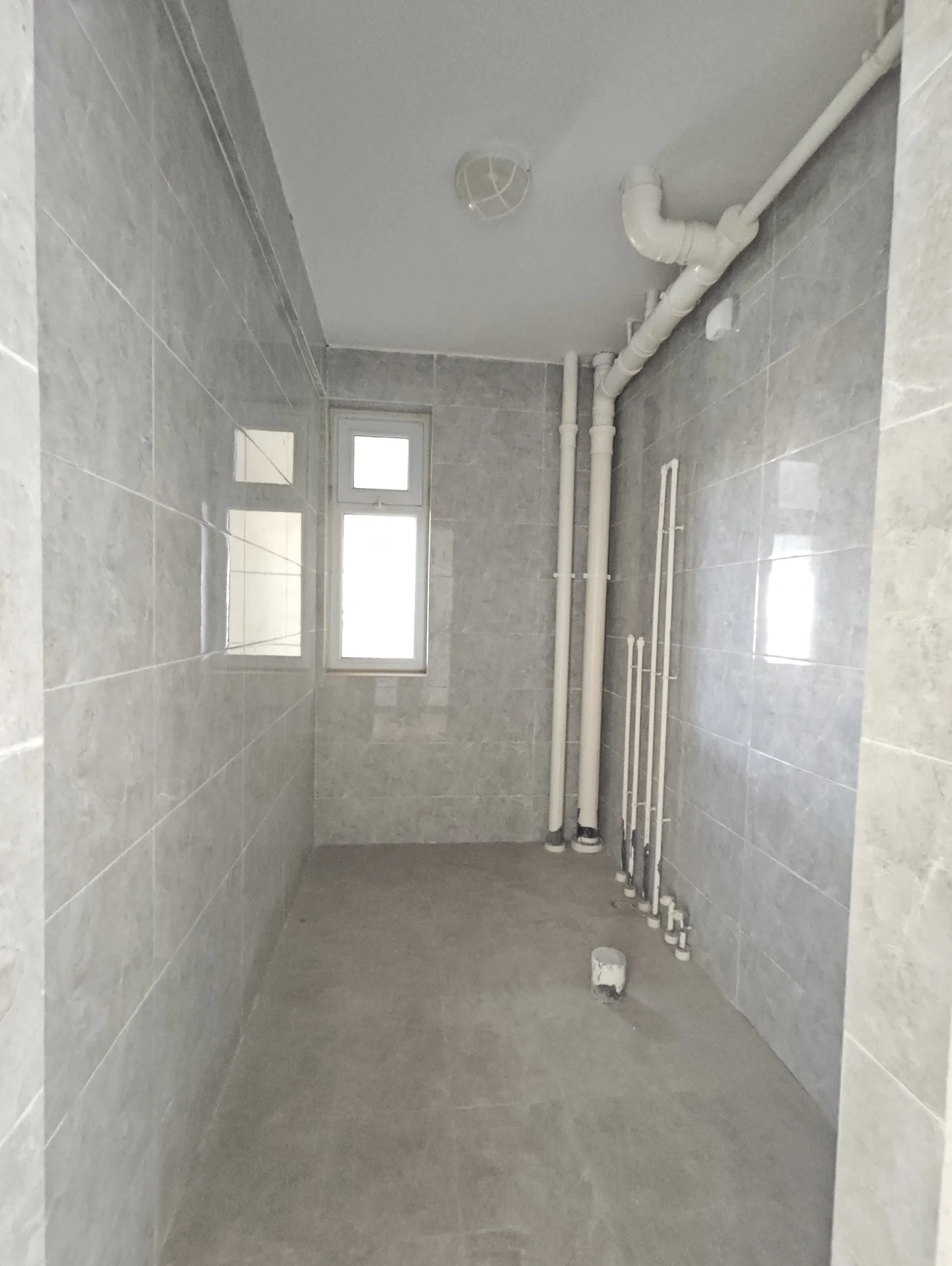 浴室以白色瓷砖装饰，采光良好，显得干净整洁，氛围宁静。瓷砖地板表明浴室维护良好，可能使用了现代材料。关键字:白色瓷砖 自然采光 干净整洁 宁静氛围 瓷砖地板 现代材料