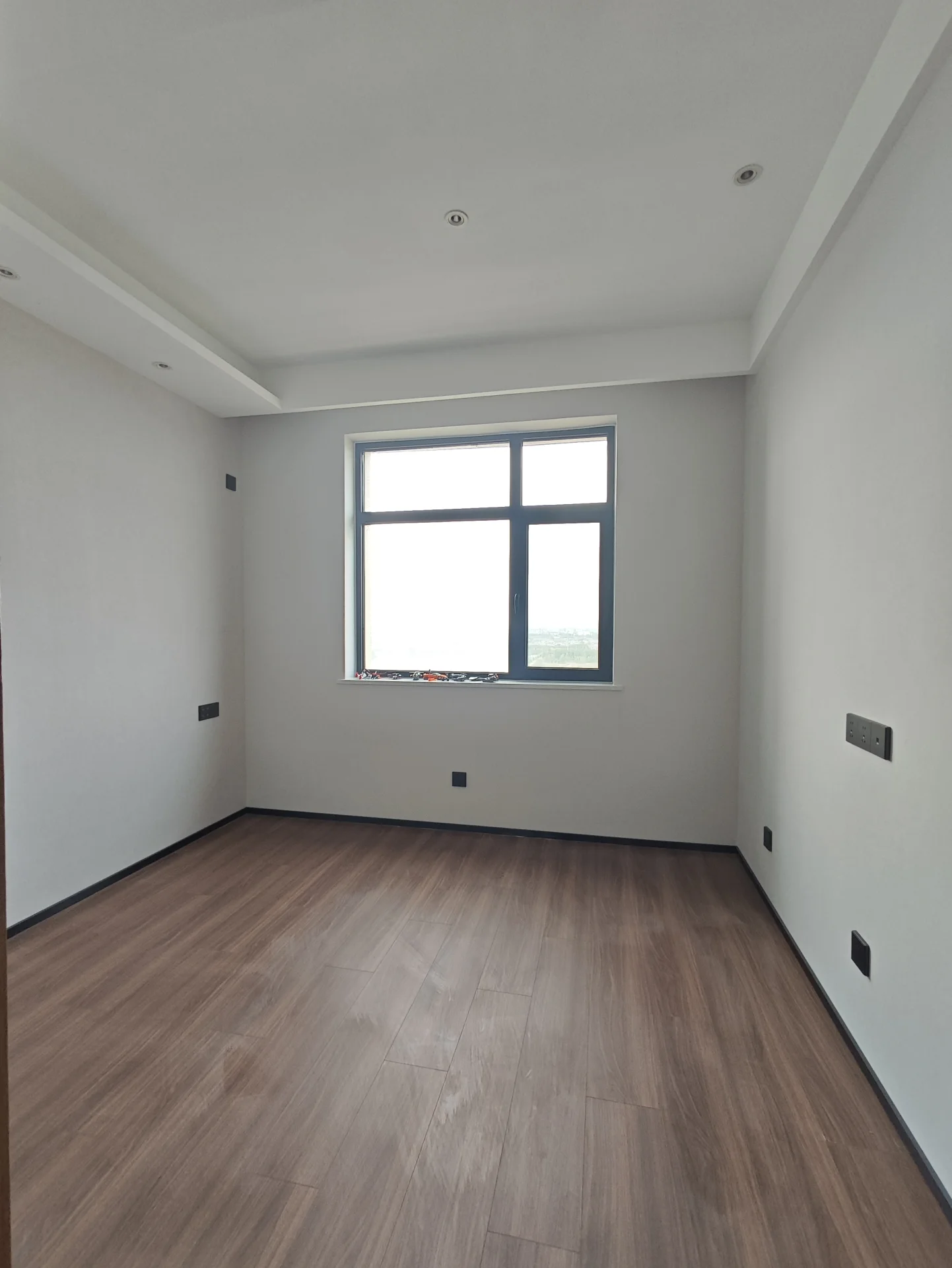 宽敞明亮的房间，洁白的墙面和天花板，自然光透过窗户洒进室内，营造出宁静舒适的氛围。简约风格的装修，没有装饰或家具，显得格外开阔。这样的空间非常适合放松或冥想。关键字:宽敞 明亮 洁白 自然光 宁静 简约风格 放松 冥想