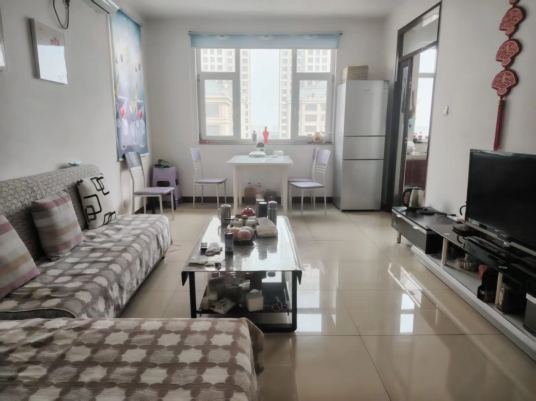 客厅干净整洁，大窗户采光充足，营造舒适温馨氛围。现代简约风格，家具布局开放，空间感强。关键字:客厅 大窗户 自然光 舒适氛围 现代简约 开放布局 空间感