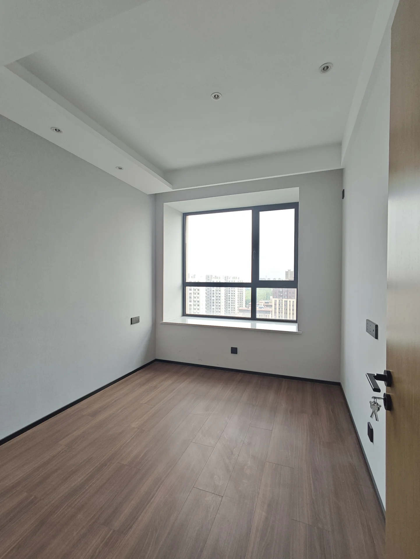 宽敞明亮的房间，白墙木 flooring，自然光透过窗户洒进室内，营造清新氛围。两把椅子暗示这里是客厅或办公室。简约整洁的风格，视野开阔，可能俯瞰城市。关键字:宽敞 明亮 白墙 木 flooring 自然光 窗户 清新氛围 两把椅子 客厅 办公室 简约风格 整洁 开阔视野 城市景色