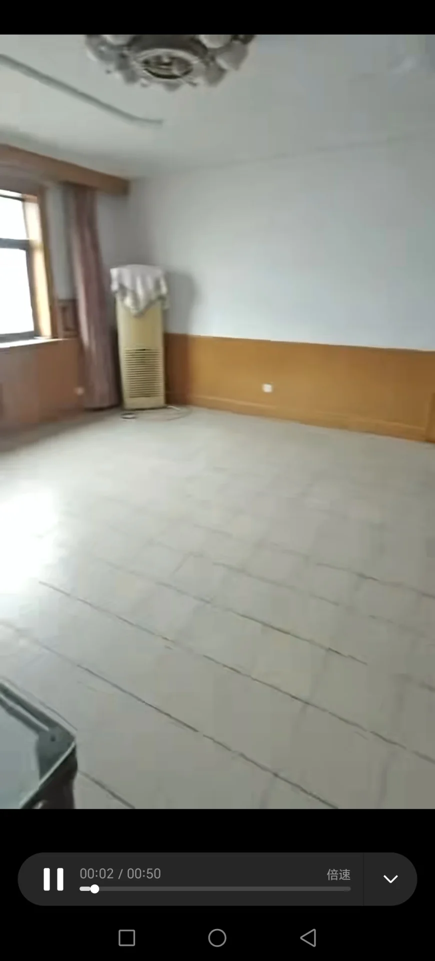 宽敞明亮的房间，白墙瓷砖地面，角落里有一张沙发和一把椅子，一侧有台灯，另一侧有花瓶。两扇窗户引入自然光，整体氛围简洁整洁。关键字:宽敞 明亮 白墙 瓷砖地面 沙发 椅子 台灯 花瓶 自然光 简洁整洁