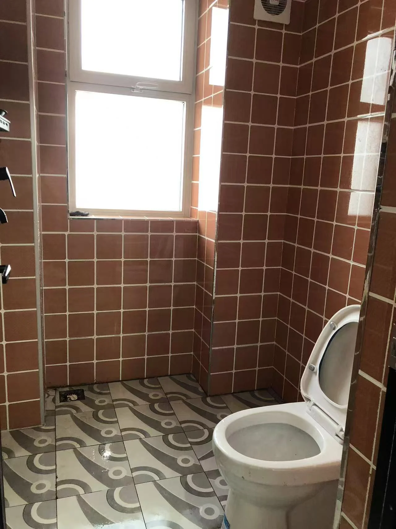 小而干净的浴室，白色马桶，粉色墙壁增添复古气息，空旷宁静，墙上镜子提升整体氛围。关键字:小浴室 白色马桶 粉色墙壁 复古风格 空旷宁静 镜子