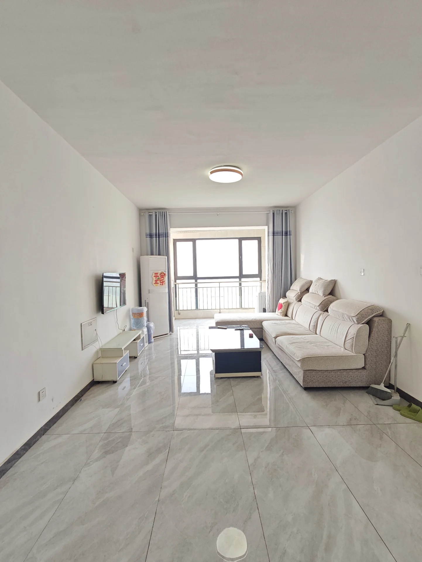 The image depicts a clean and well-organized living room with white walls. There is a large window that allows natural light to fill the space, creating an inviting atmosphere. A couch is situated in front of the window, providing a comfortable seating area for relaxation or entertainment. 

In addi 此处省略了... 多少字来着? .. 忘了...关键字: