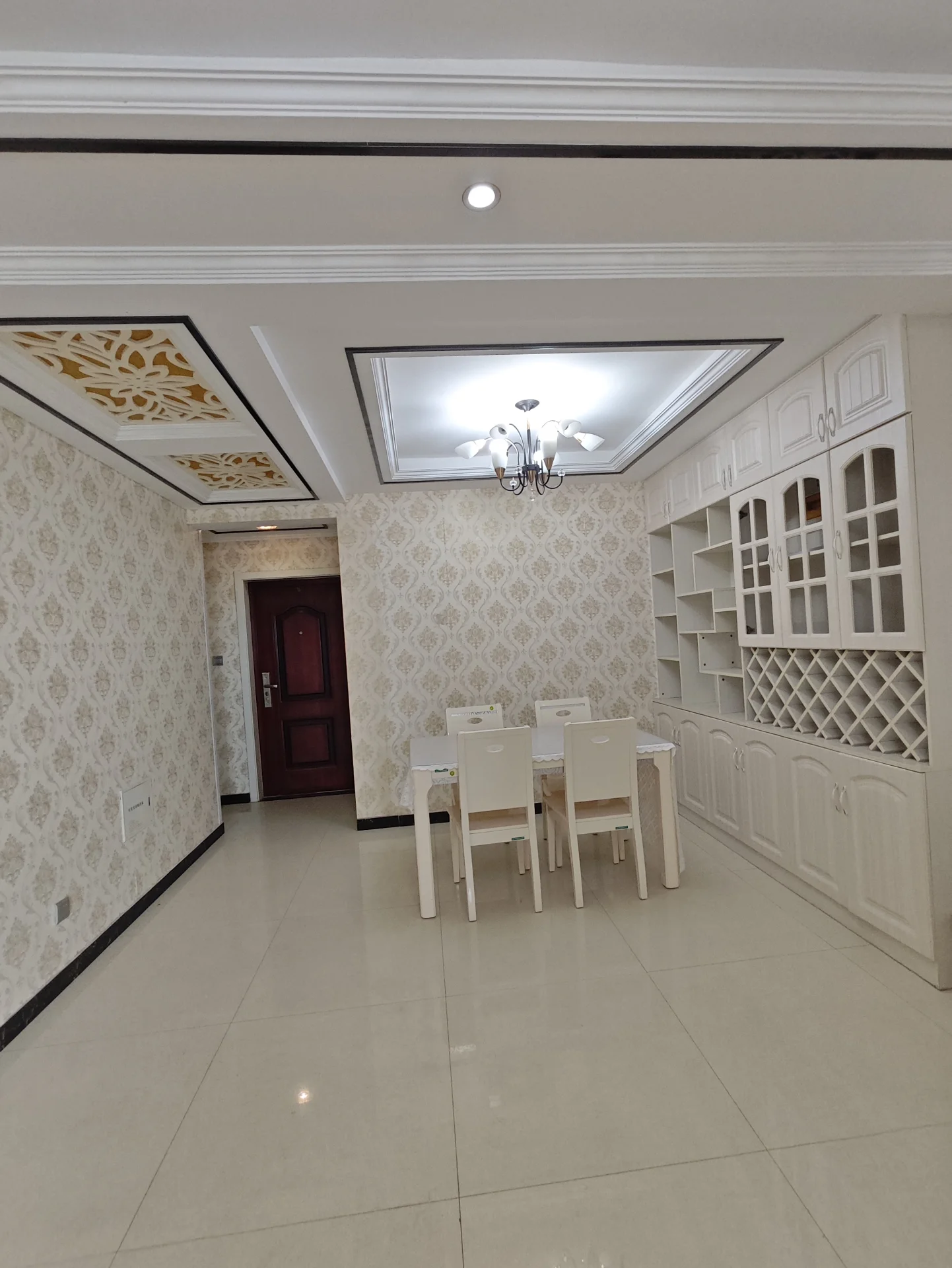 宽敞明亮的房间，白色墙面和地板，中央摆放着餐桌和椅子，营造出温馨的聚会氛围。整体环境宁静宜人，适合举办活动或与家人朋友共度宁静晚餐。关键字:宽敞 明亮 白色墙面 餐桌 椅子 温馨氛围 宁静环境