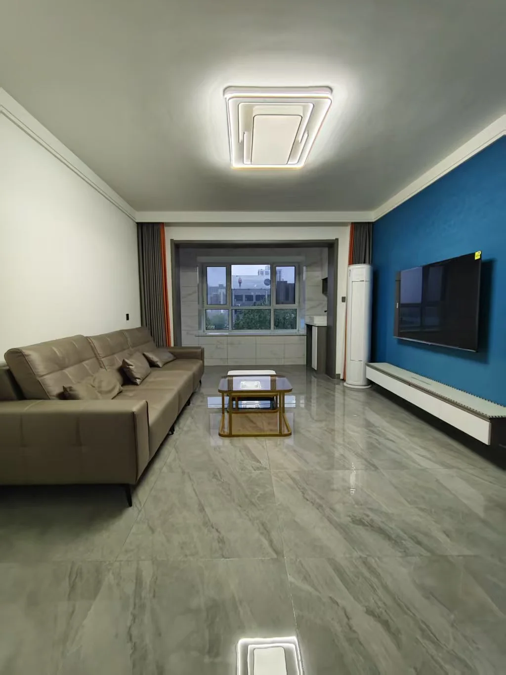 宽敞明亮的现代客厅，棕色皮质沙发和咖啡桌，电视墙挂，两把椅子点缀，中央冰箱，大窗户引入自然光。关键字:现代客厅 棕色皮质 沙发 电视墙挂 椅子 冰箱 大窗户