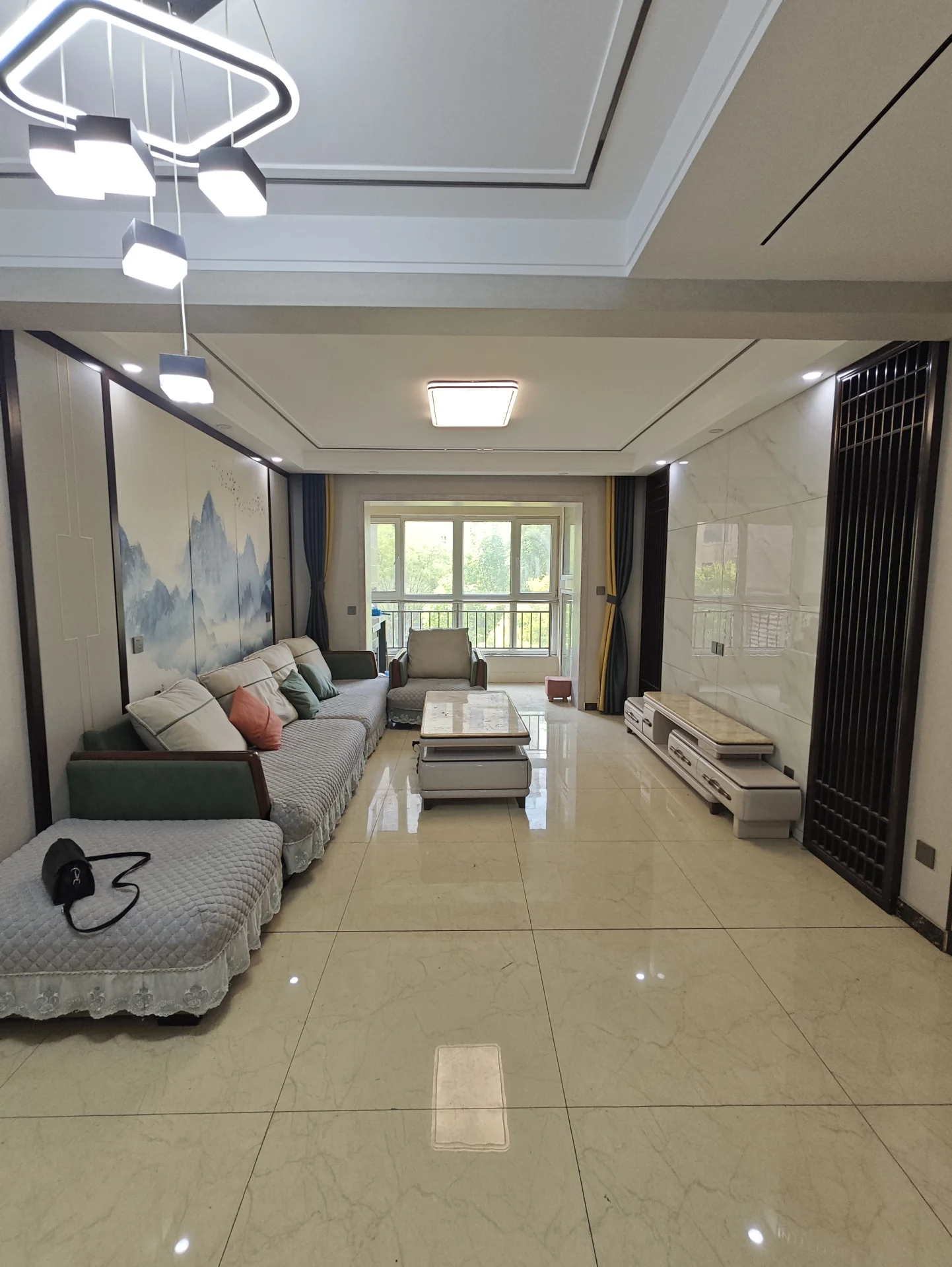 宽敞明亮的开放式客厅，白墙高顶，中央摆放着沙发、椅子和餐桌，两侧各有 beds。整体氛围清新雅致，现代风格突显开阔感，宁静宜人适合放松或招待客人。关键字:宽敞 明亮 开放式客厅 白墙 高顶 沙发 椅子 餐桌 beds 清新雅致 现代风格