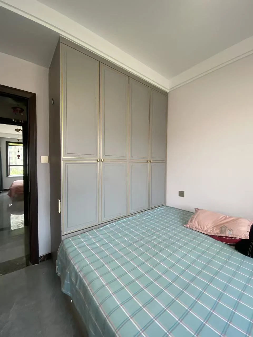 卧室整洁有序，床铺整齐，衣柜和梳妆台靠近床脚。宽敞的空间和宁静的氛围，让人感到放松和舒适。关键字:卧室 床 衣柜 梳妆台 整洁 宁静 舒适