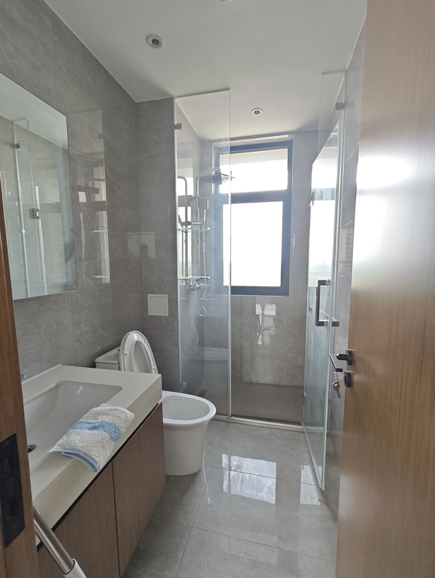 白色马桶、水槽和浴缸的浴室，明亮整洁，大窗户引入自然光，现代简约设计，宁静放松氛围，适合个人护理和自我反思。关键字:白色马桶 水槽 浴缸 明亮 整洁 大窗户 自然光 现代简约设计 宁静放松氛围