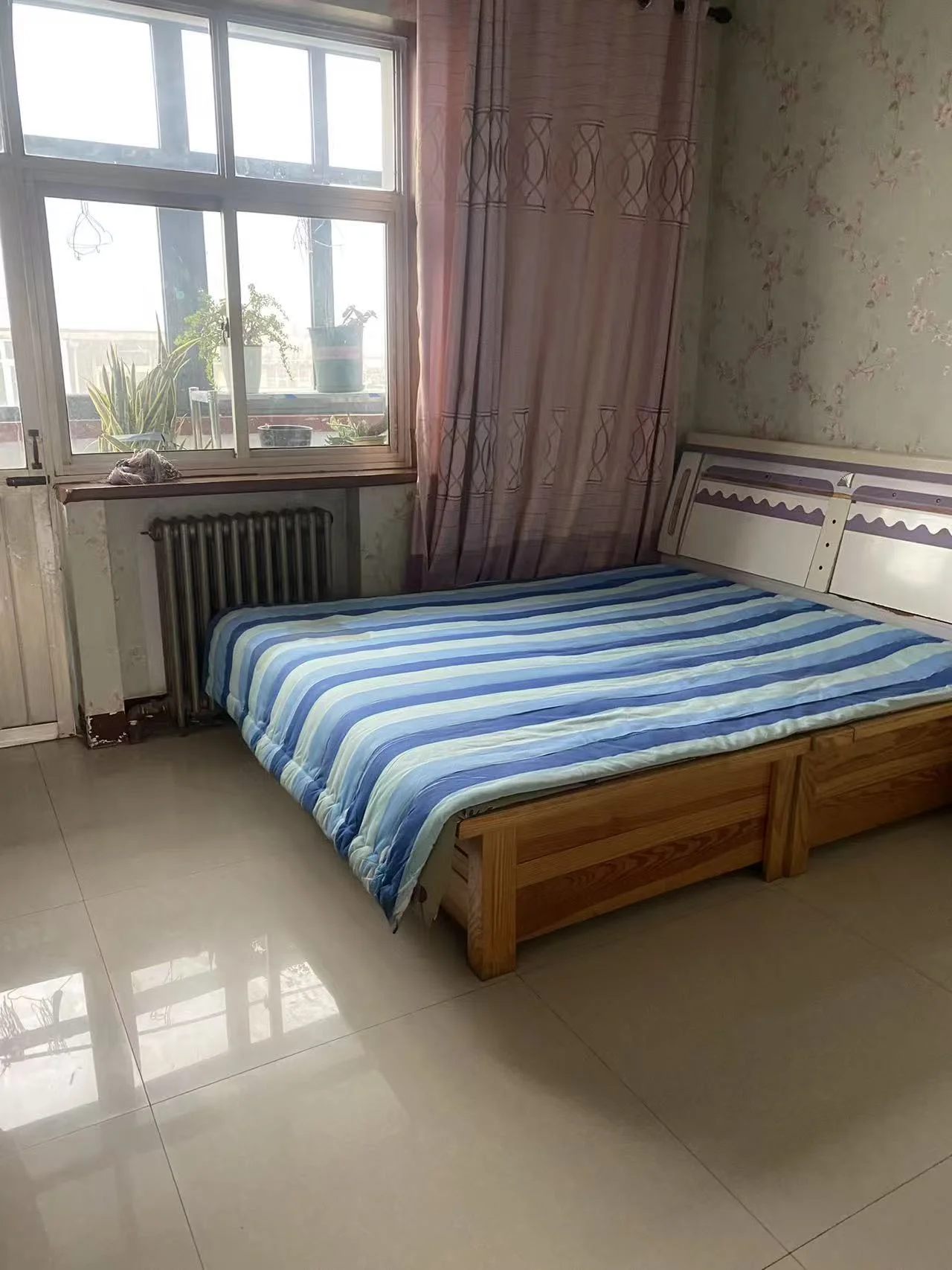 小卧室，整洁的双人床，两侧各有一扇窗户，墙上粉色与白色搭配，营造出宁静和平和的氛围。关键字:小卧室 双人床 窗户 粉色 白色 宁静和平和