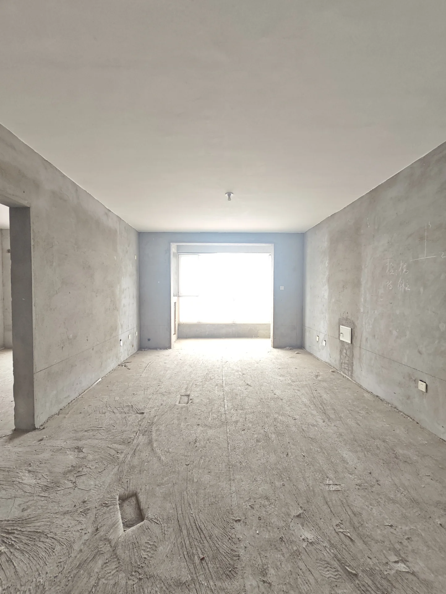 空旷未完成的房间，混凝土地板，水泥墙，白色天花板，自然光透过窗户洒入。氛围宁静，无人员。可能具有工业或实用风格。关键字:空旷 未完成 混凝土地板 水泥墙 白色天花板 自然光 宁静 无人员 工业风格 实用风格