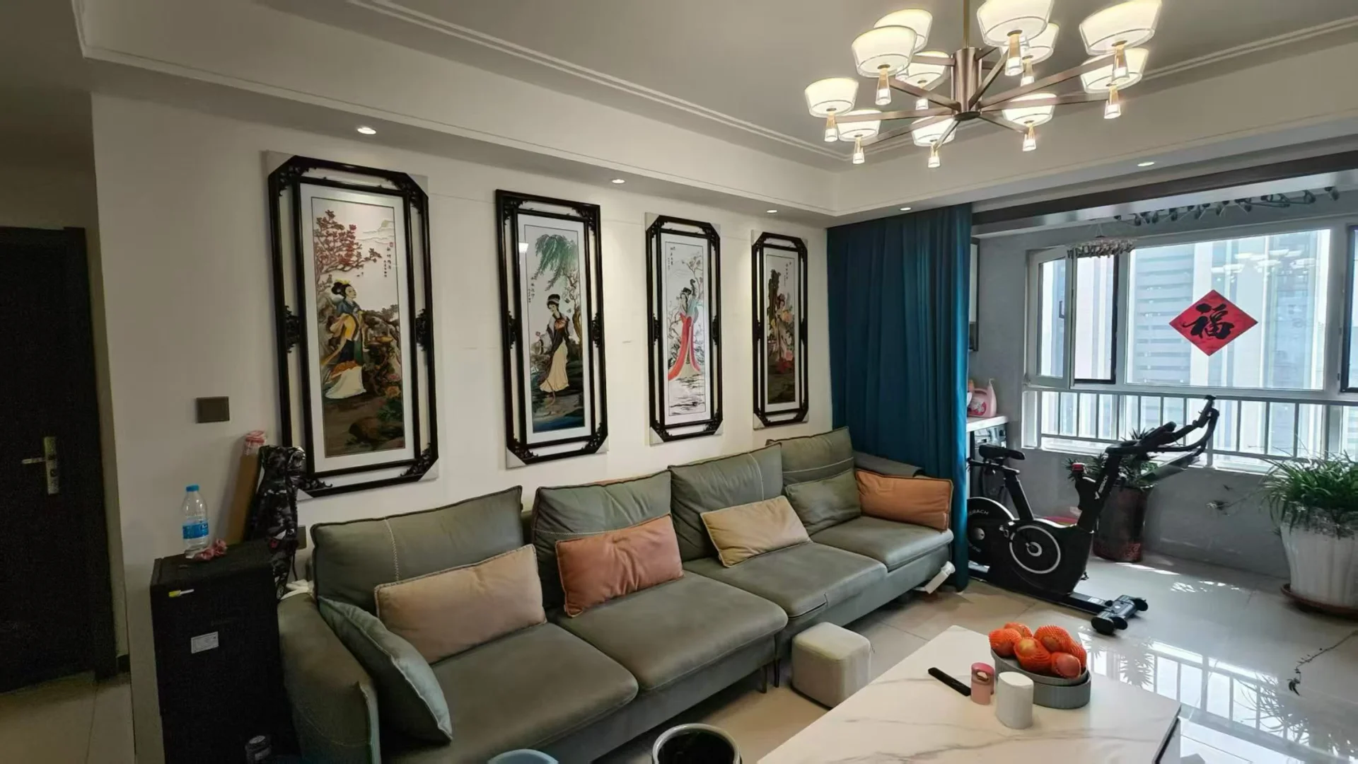 客厅内摆放着沙发、椅子和餐桌，墙上挂着大尺寸电视和艺术画作，两盆植物增添生活气息，氛围温馨。关键字:客厅 沙发 椅子 餐桌 自行车 大屏幕电视 艺术画作 植物 瓶子 花瓶