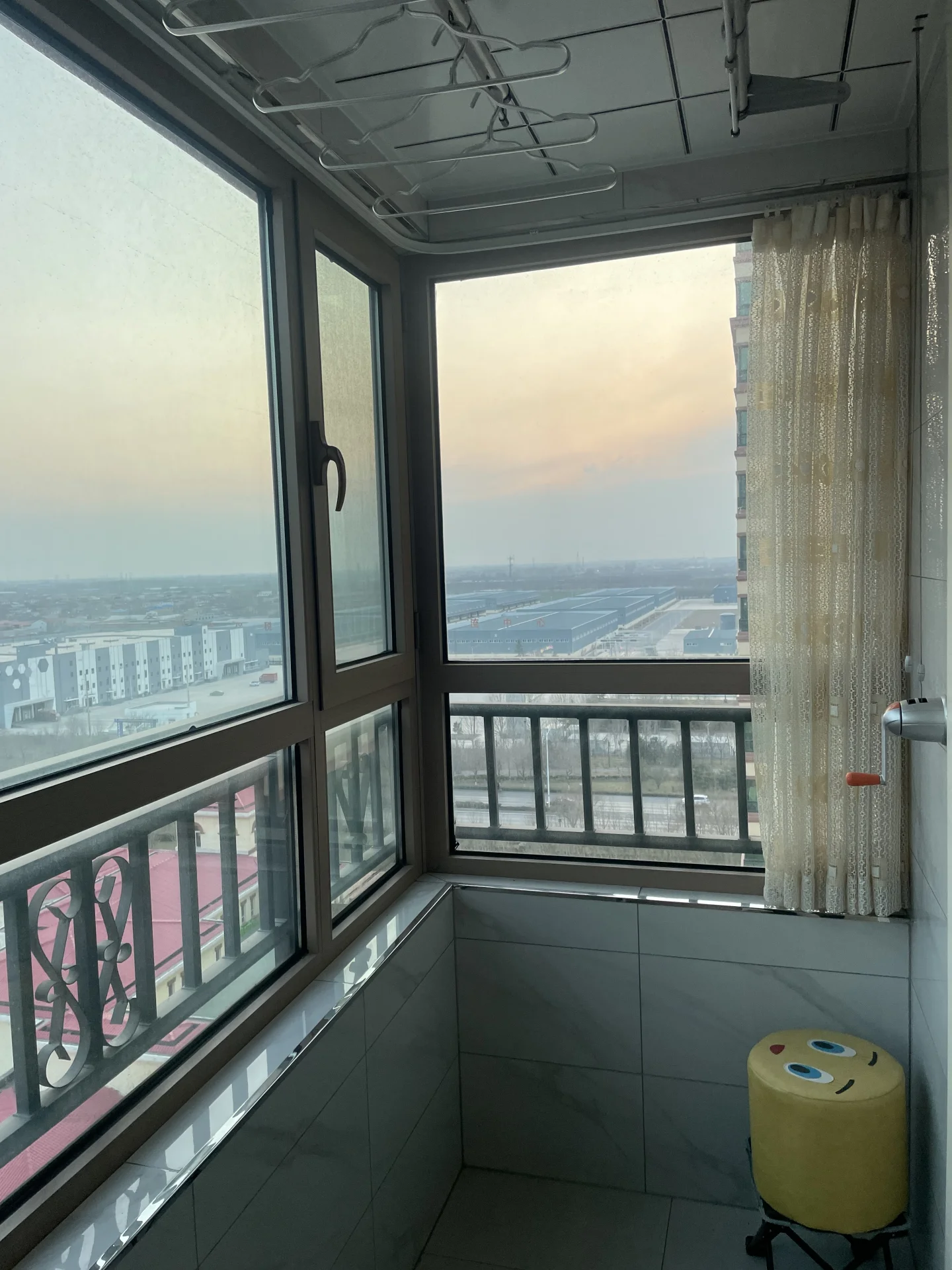 从高层建筑的窗户向外俯瞰城市远景，展现了广阔的城市地平线，光线柔和，具有宁静的城市景观氛围。