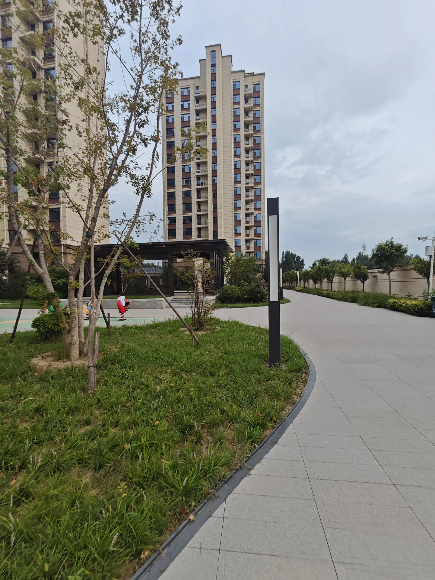 多栋高层住宅楼的外部立面清晰可见，建筑风格统一，周围有绿化带和道路，整体呈现出社区住宅的宁静和谐氛围。