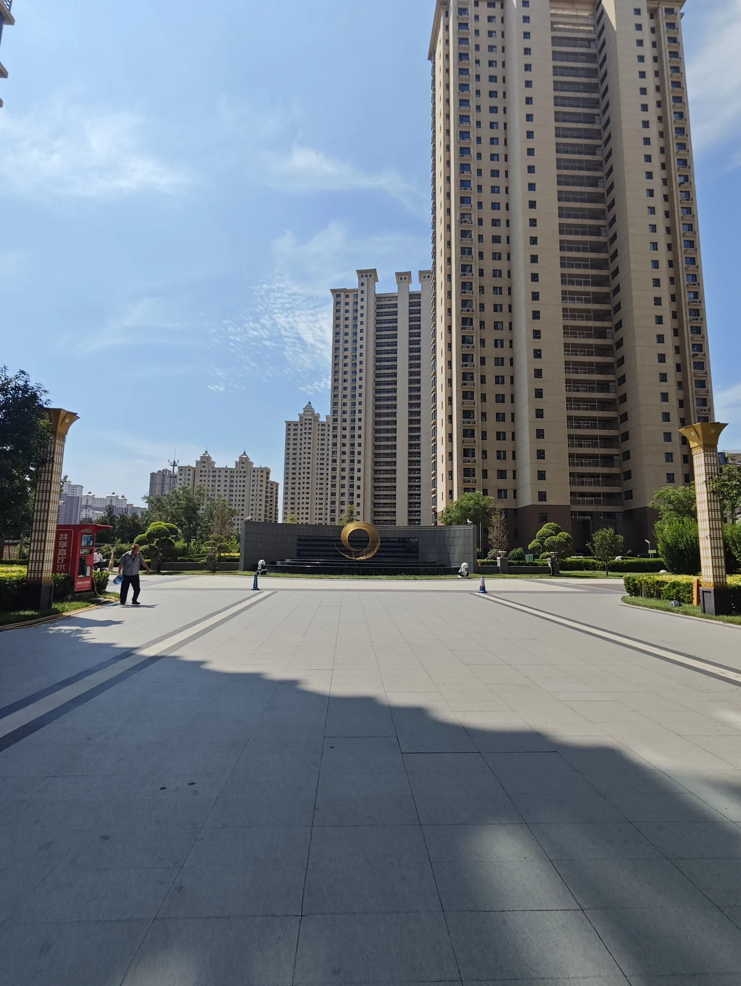 多栋高层住宅建筑的外部立面清晰可见，建筑风格统一，周围有绿化带和城市街道景观，整体呈现现代都市的居住氛围。