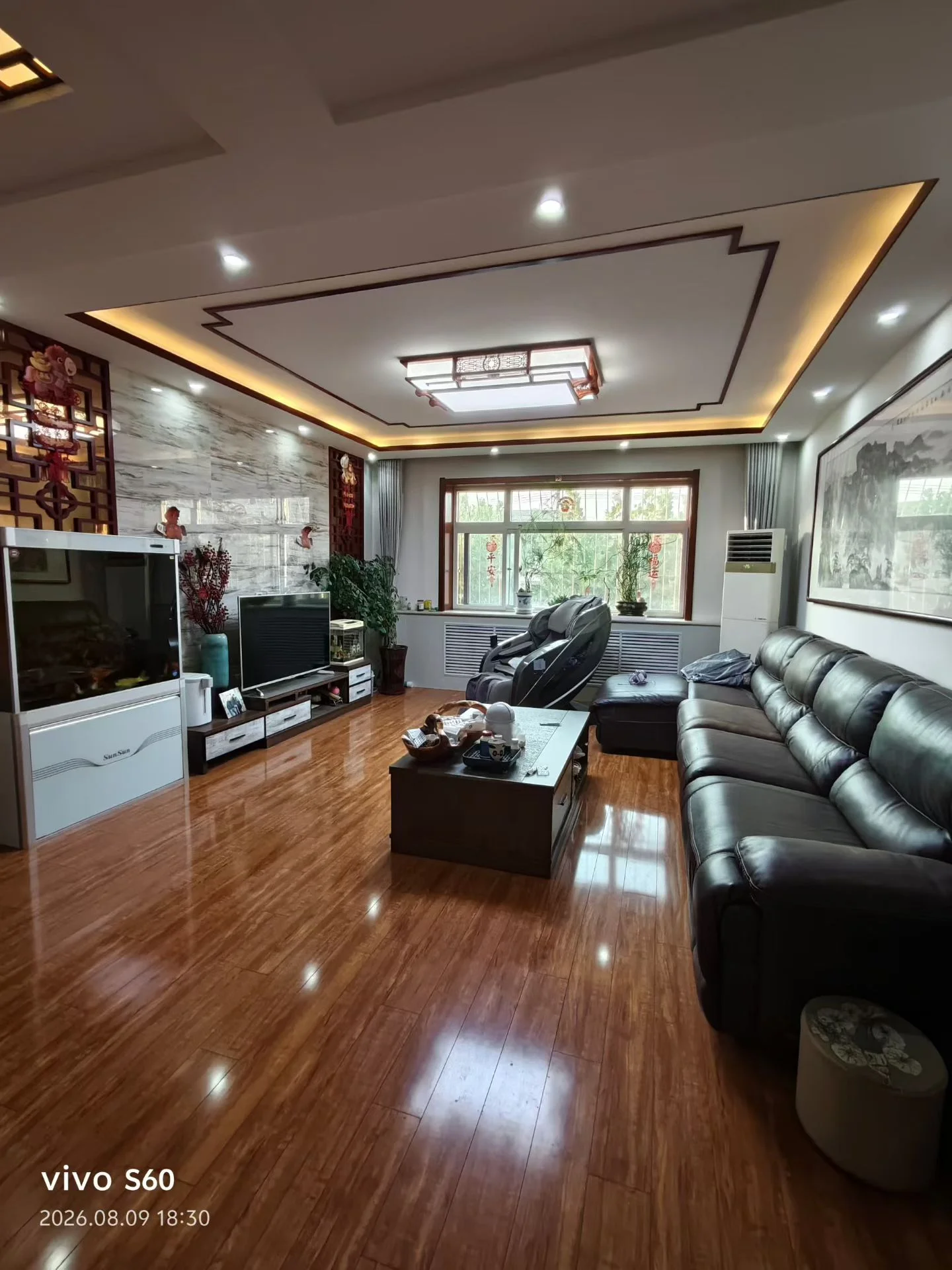 客厅场景，墙面采用现代简约装修风格，配有大型平板电视和简约沙发。采光充足，整体呈现现代简约装修风格，氛围整洁舒适。