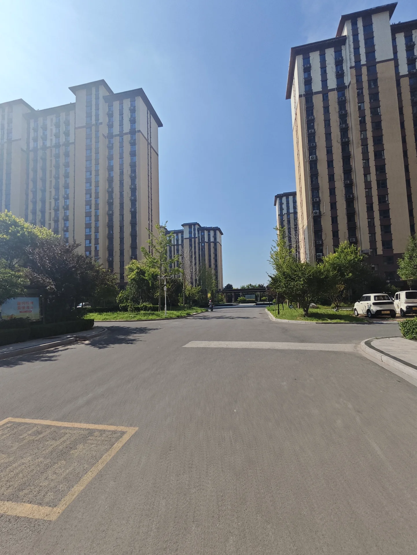 多栋高层住宅楼的外部立面清晰可见，建筑风格统一，周围有绿化带和街道，整体呈现出社区住宅的宁静与现代感。