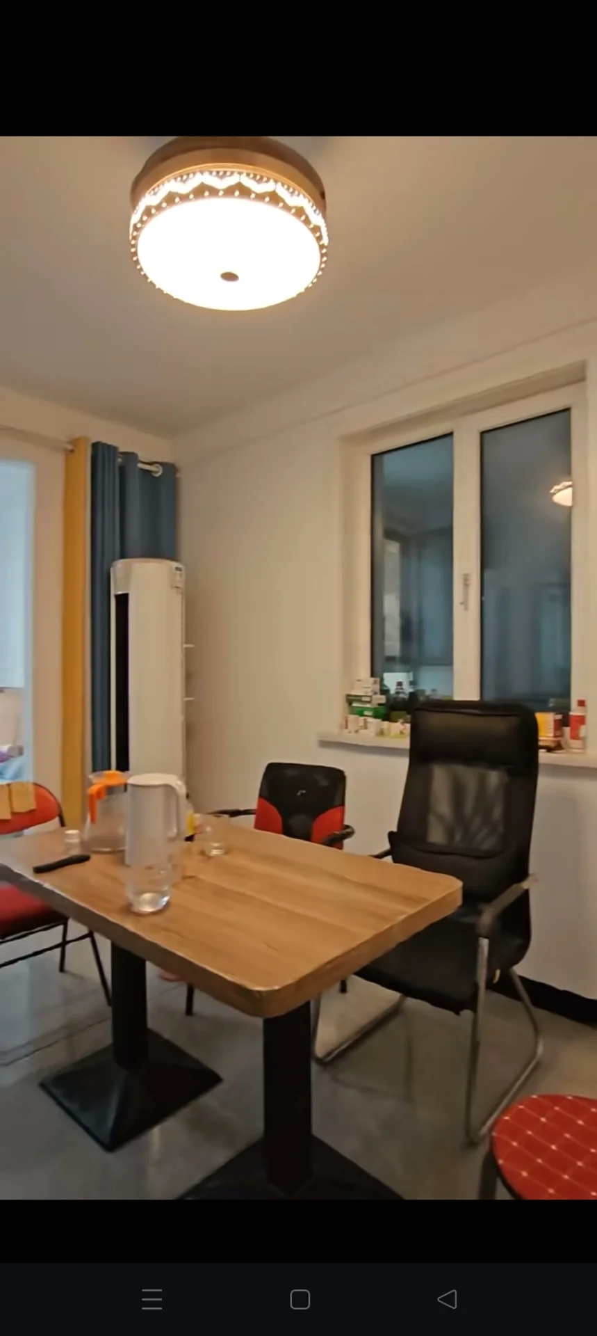 用餐场景，木质餐桌和椅子布置，上方悬挂着一个圆形吊灯。光线柔和，整体呈现温馨、居家用餐氛围。