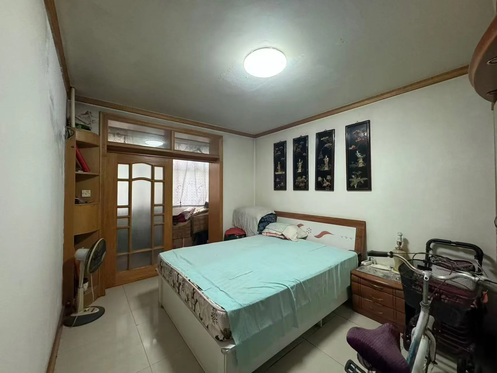 卧室场景，装修风格简洁，配有床铺、衣柜和墙面装饰。采光良好，整体氛围整洁舒适。