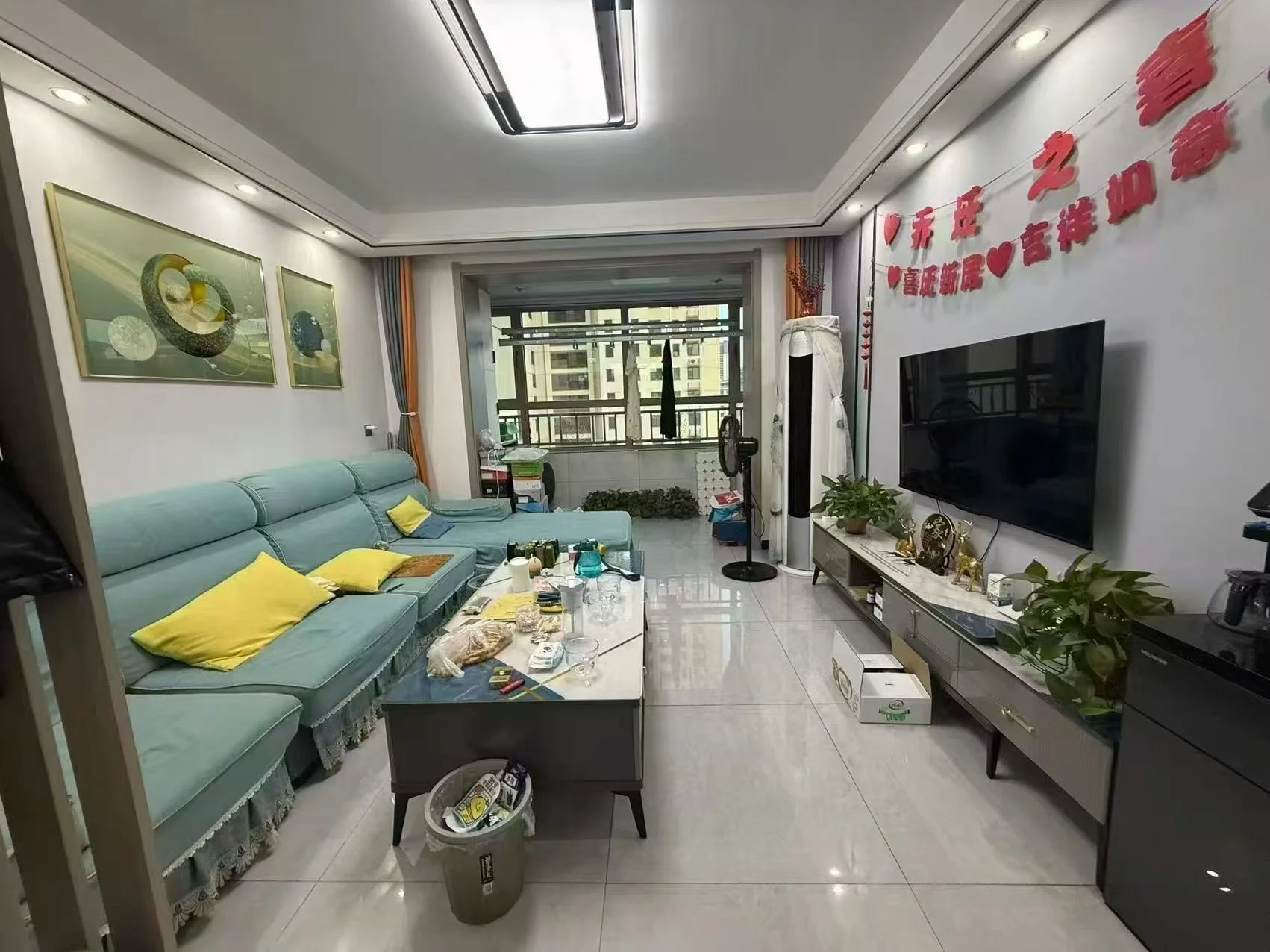 客厅场景，墙面采用浅色调，配有L型沙发和茶几。采光良好，整体呈现现代简约装修风格，氛围整洁舒适。