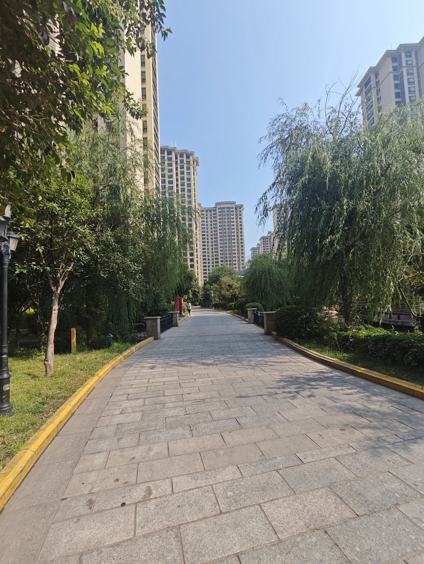 多栋高层住宅楼的外部立面，建筑立面简洁，周围环绕着茂密的树木和绿化带，整体呈现出宁静、宜居的城市社区氛围。