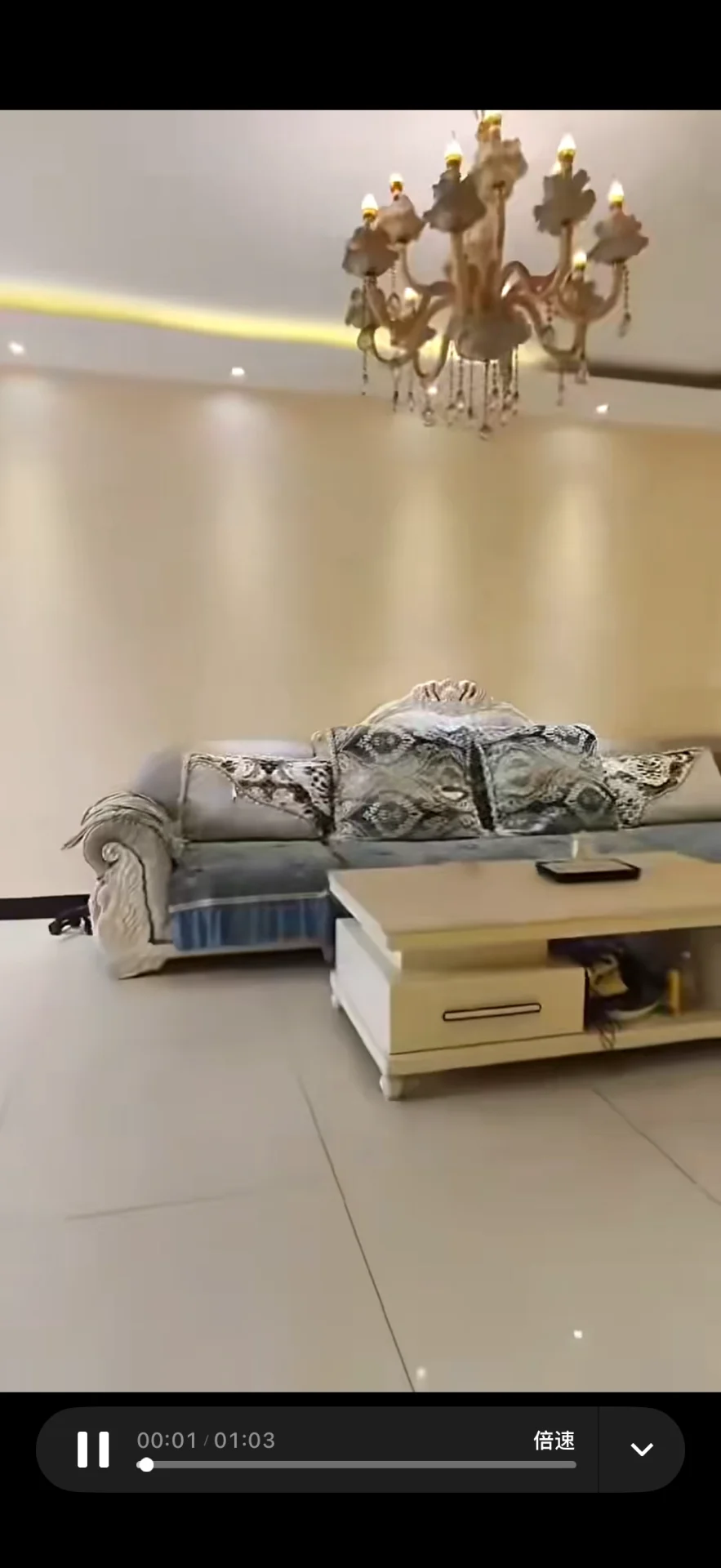 客厅场景，沙发和茶几是核心家具，配有华丽的吊灯，整体呈现精致且略带奢华的室内装修风格，采光良好，氛围温馨舒适。