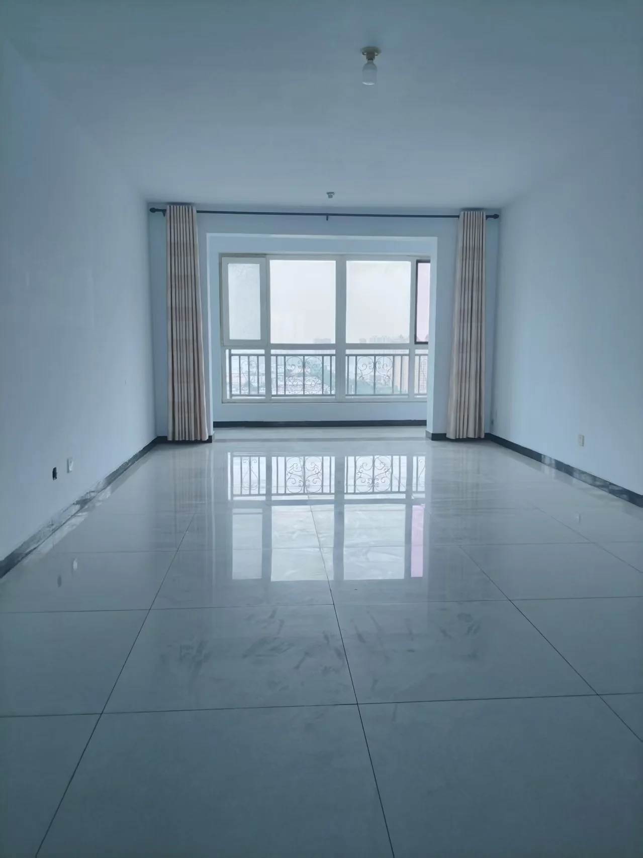 一个光线充足的室内空间，地面铺设大面积白色瓷砖，配有两扇带有垂直装饰线条的窗户，整体呈现简洁明亮的现代简约装修风格。
