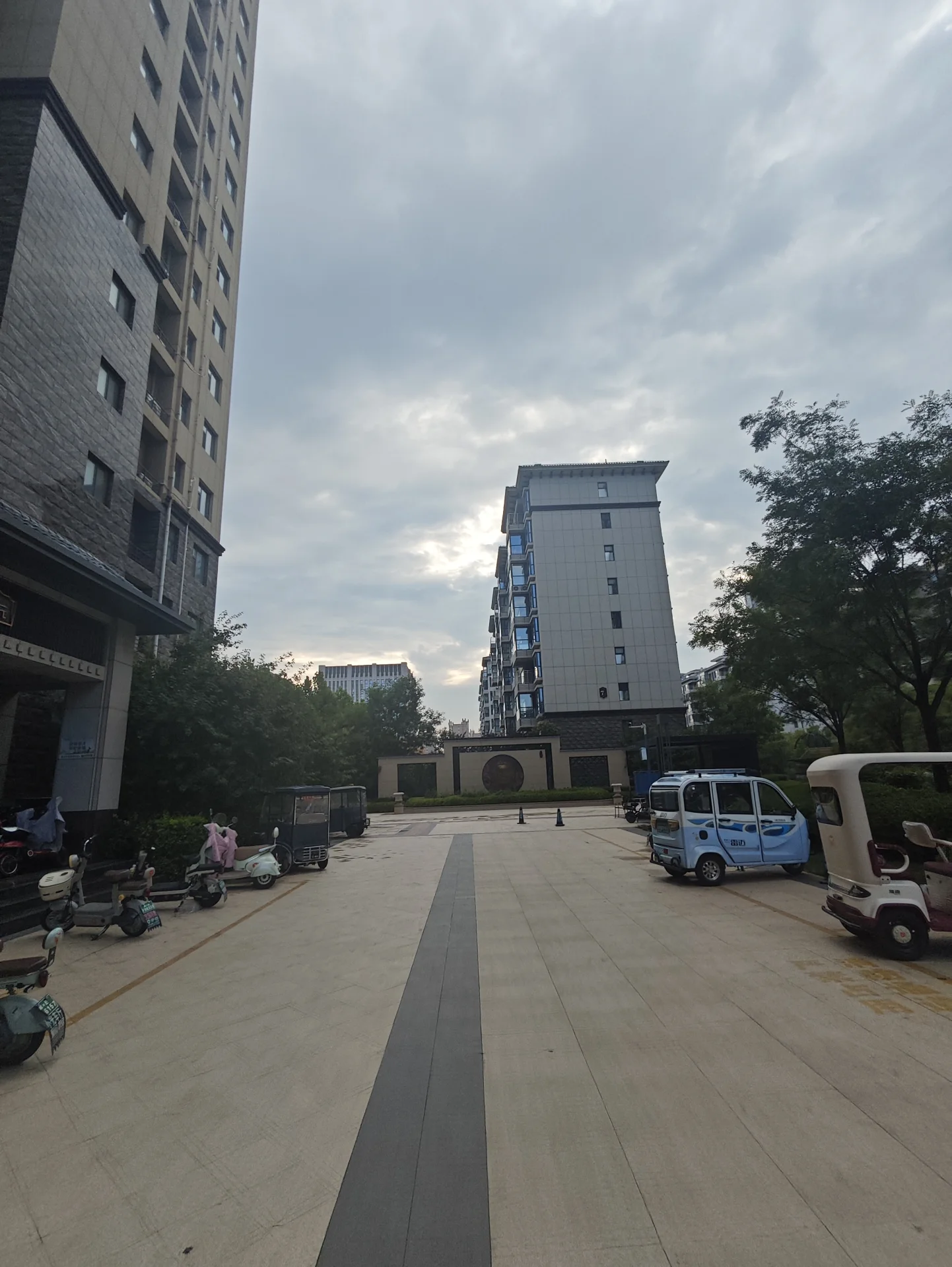 多栋高层住宅的外部立面清晰可见，建筑风格统一，周边有停车场和绿化带，整体呈现现代城市社区的居住环境氛围。