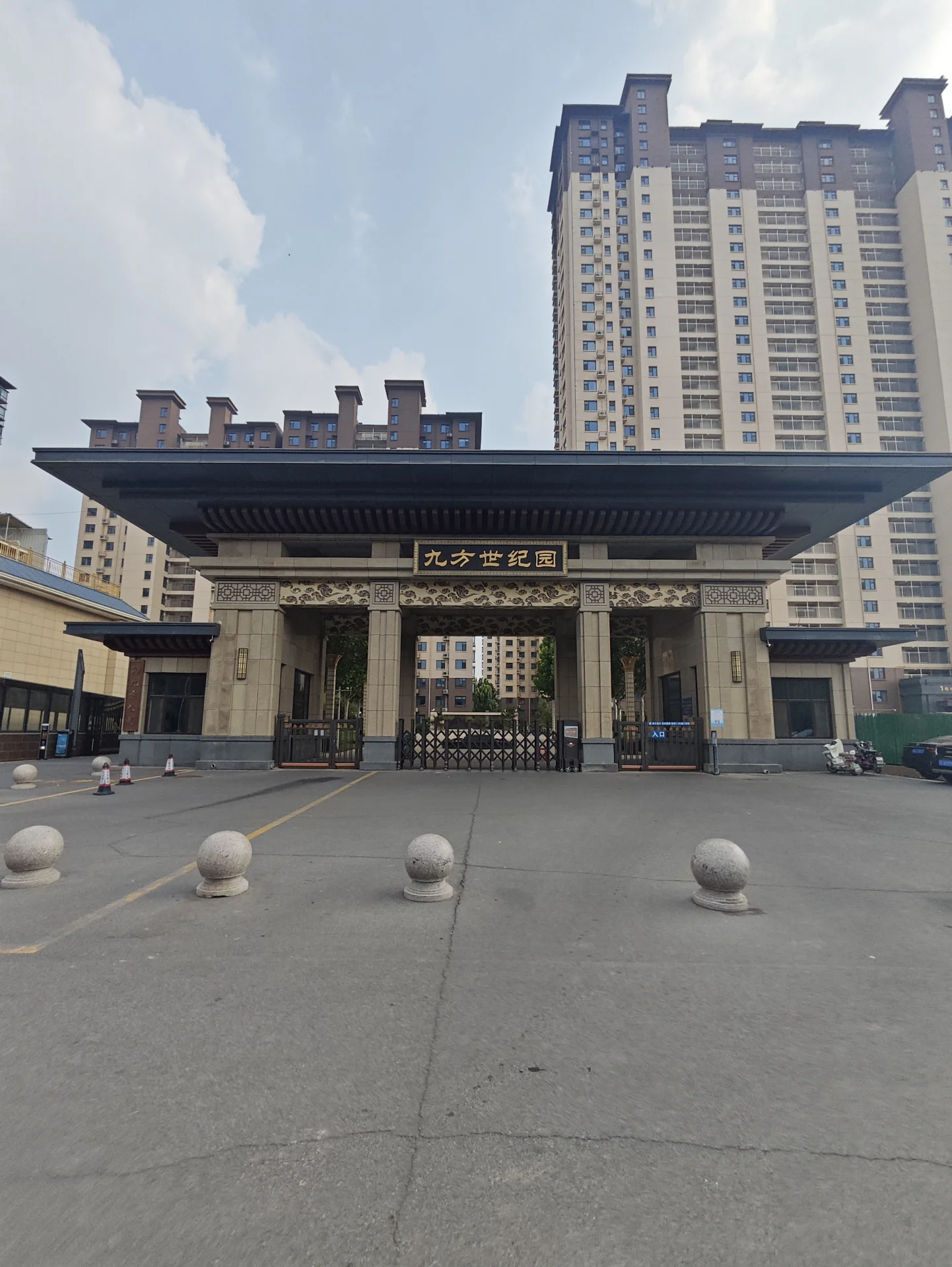 多栋高层住宅楼的外部立面清晰可见，建筑风格统一，入口区域设有宽阔的门廊和低矮的景观元素，整体呈现出城市社区的宏大与秩序感。