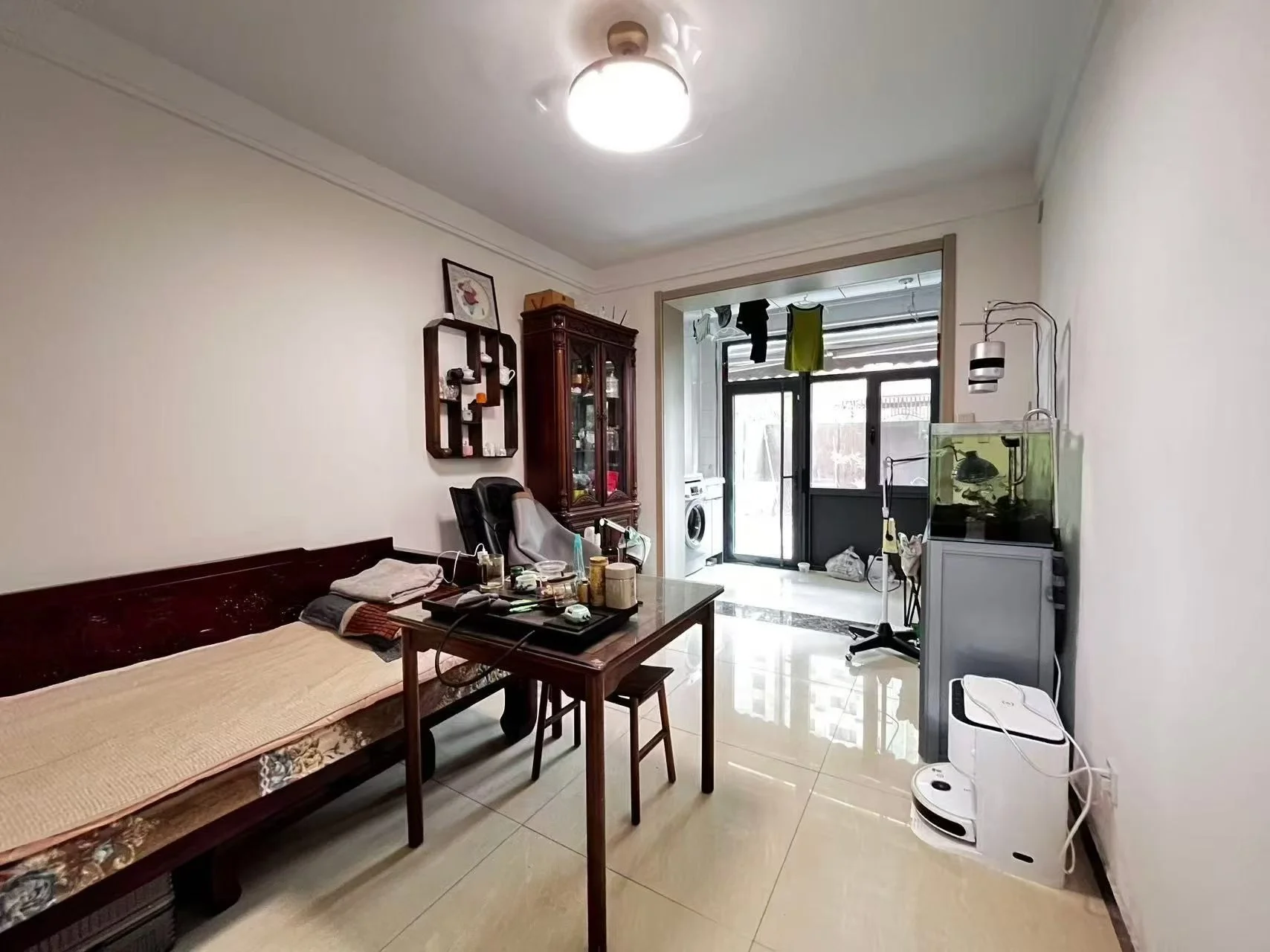 卧室或多功能室场景，装修风格偏向传统木质家具，采光良好，整体呈现温馨、陈设齐全的居住环境。