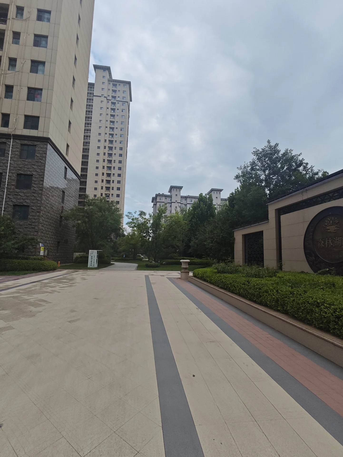 多栋高层住宅的外部立面清晰可见，建筑风格统一，周围有绿化带和公共道路，整体呈现出城市社区的居住环境氛围。