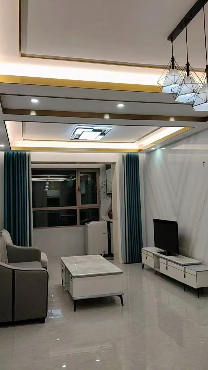 现代简约风格的住宅内部空间，地面铺设浅色大理石或瓷砖，配有现代简约风格的沙发和电视柜。采光良好，整体装修干净整洁，营造出温馨舒适的居住氛围。