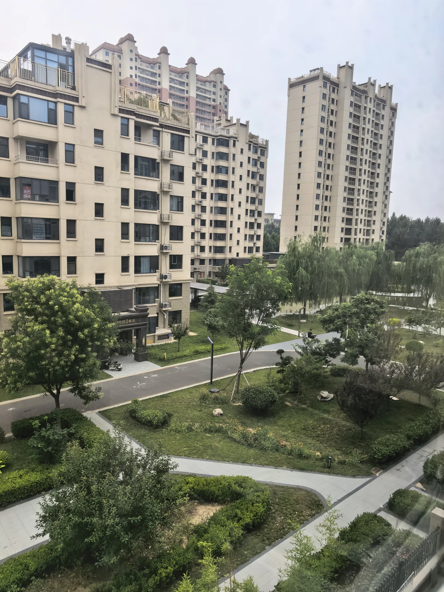 多栋高层住宅楼的外部立面清晰可见，建筑风格统一，周边绿化带和社区景观环绕，整体呈现出城市居住社区的宁静和谐氛围。