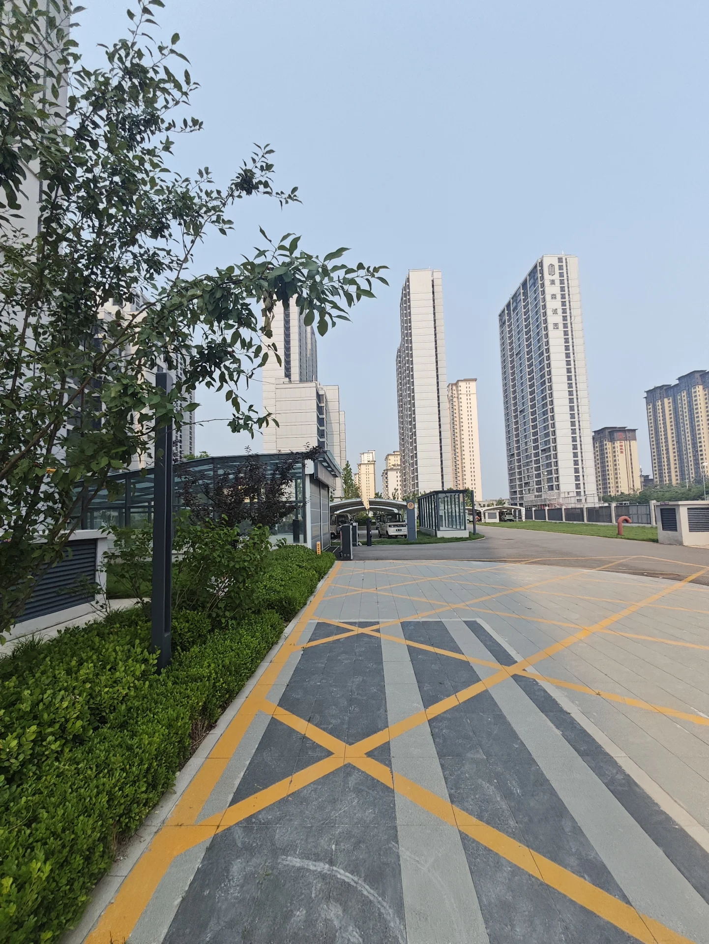 城市街道，高楼林立，人行道旁有停车场，一名行人正在行走，一辆公交车停在停车场。场景展现了城市的生活和活动，各种城市基础设施和交通工具元素。