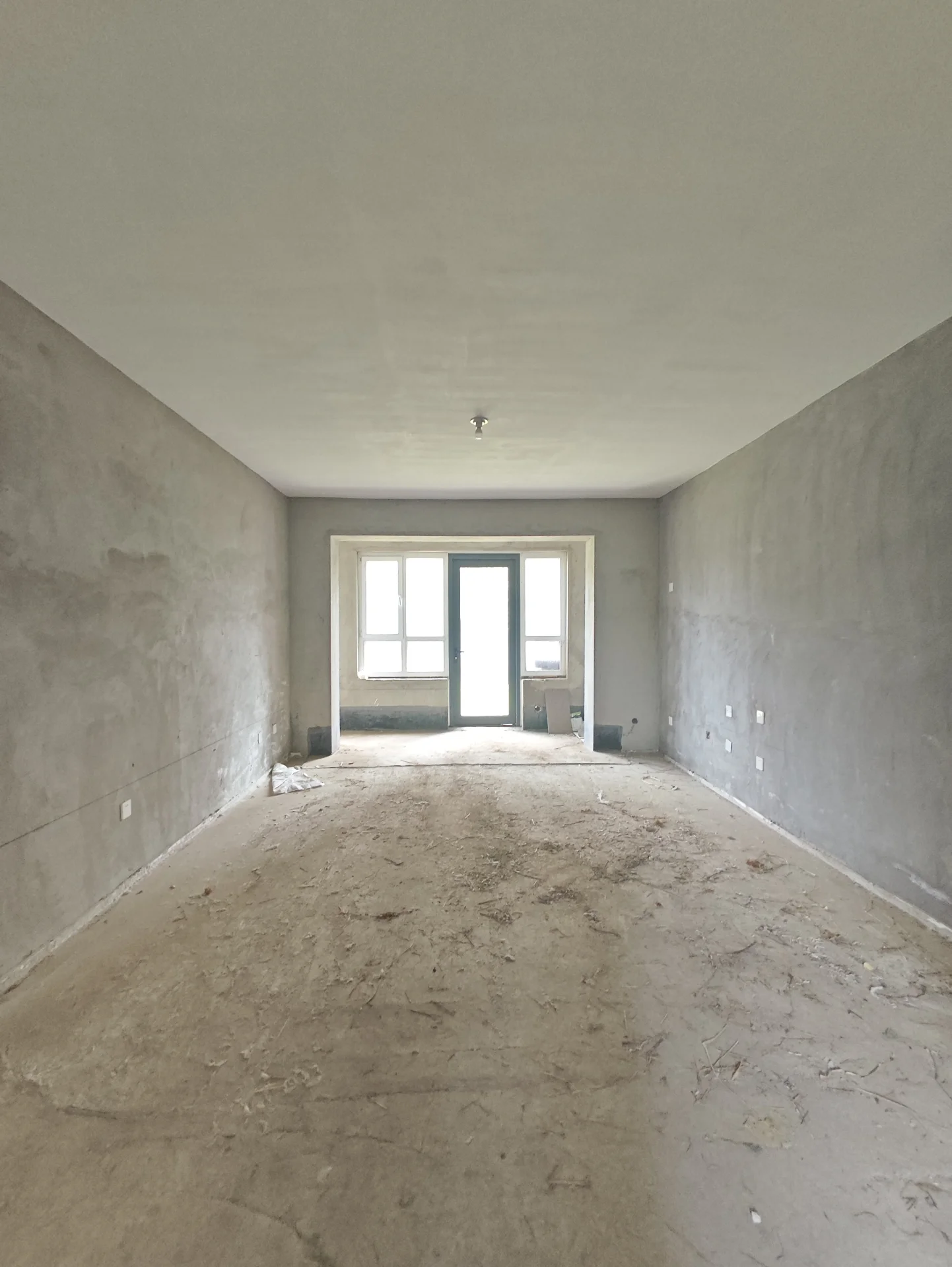 空房间，混凝土地面和墙壁，看起来正在进行建设或翻新，没有家具或其他物体的可见迹象。气氛安静而平静，房间的空旷强调了正在进行的工作。房间内没有人类存在，进一步强调了建设或翻新的过程。