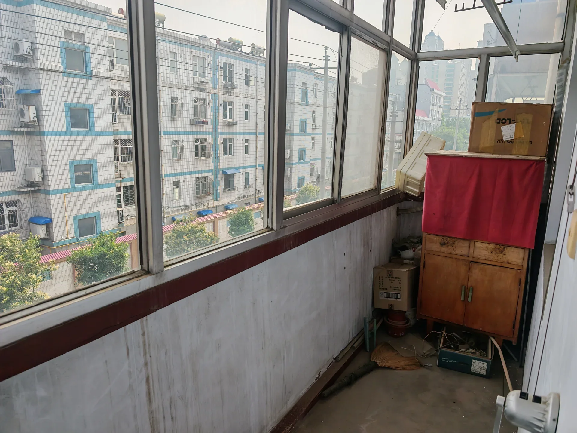 多层住宅的外部立面，采用浅色外墙和多格窗户结构，展现出典型的城市社区建筑风格，整体氛围是日常居住环境。