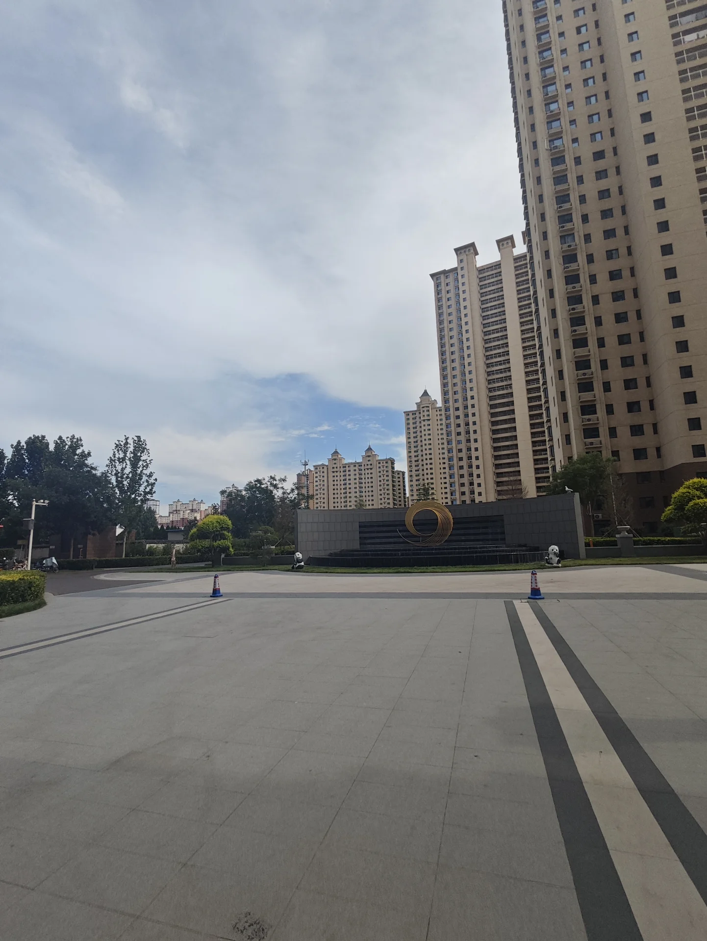 多栋高层住宅楼的外部立面清晰可见，建筑风格统一，配有低矮的绿化带和社区公共区域，整体呈现出城市住宅区的建筑景观氛围。