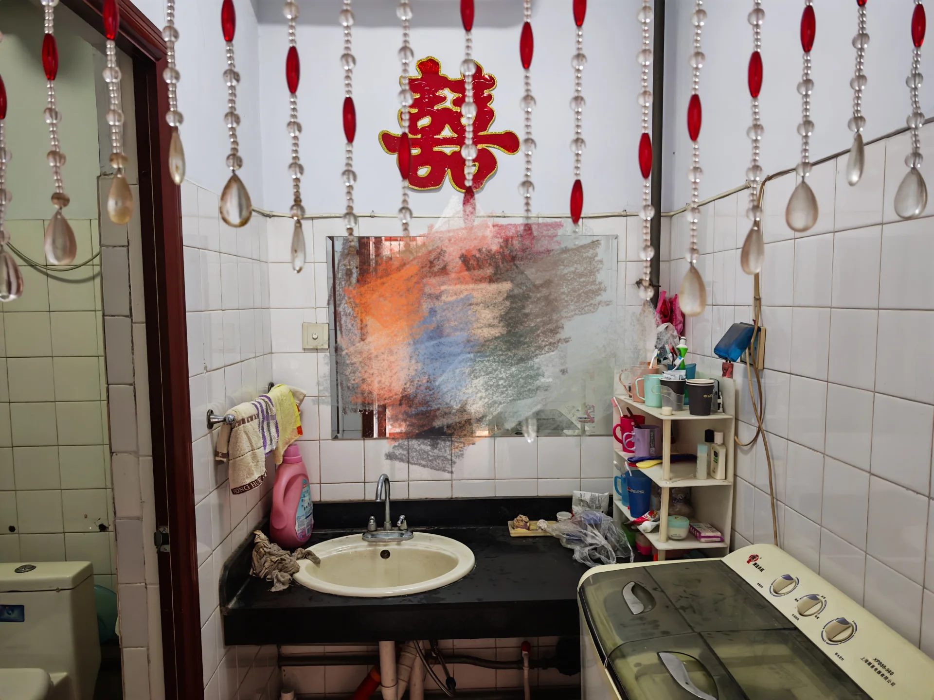 小浴室，有洗手台、马桶和洗衣机，墙面为白色瓷砖，简洁实用美观。