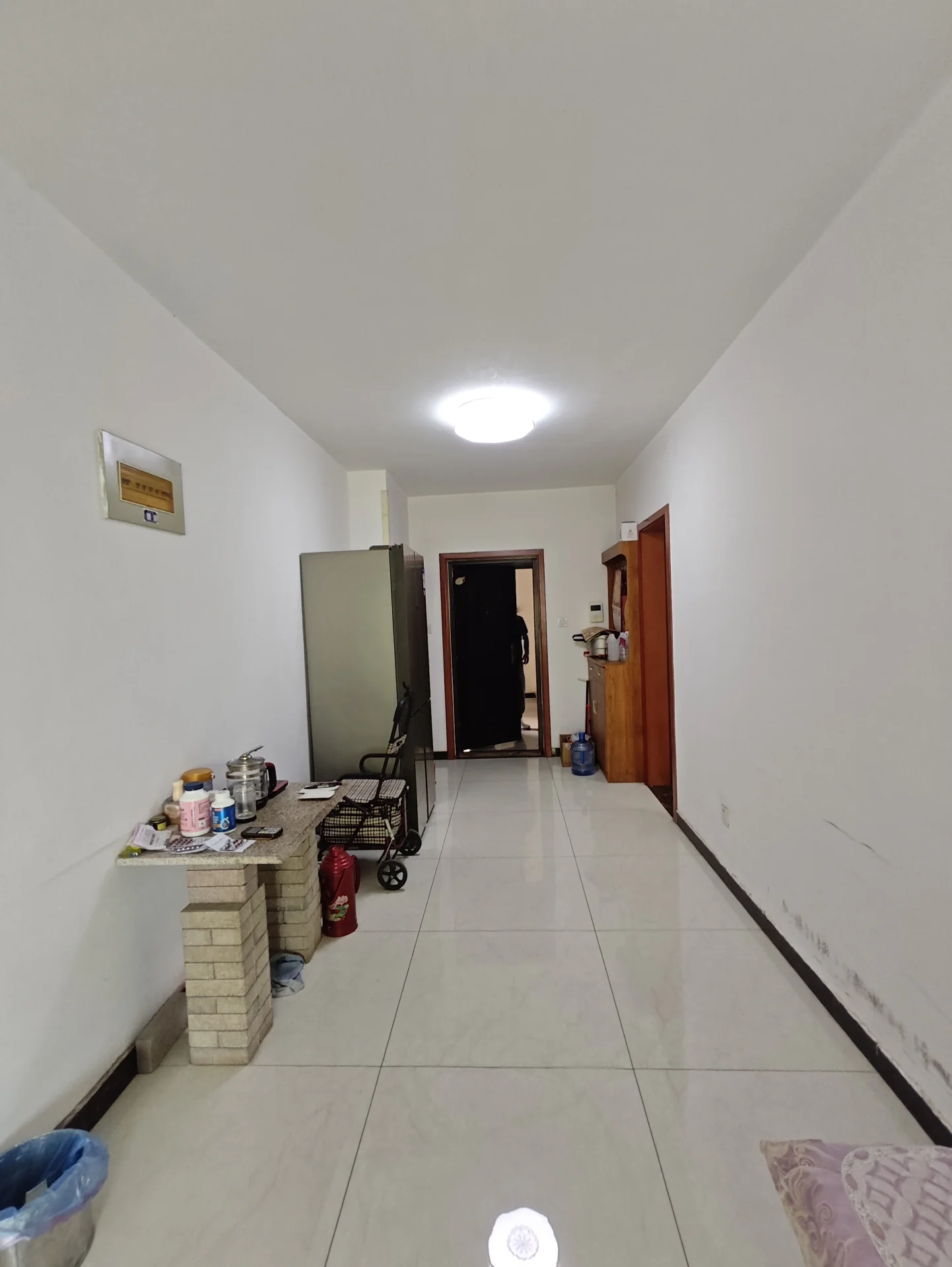 简约实用的厨房或餐厅区域，白色墙壁和浅色瓷砖地板，明亮整洁