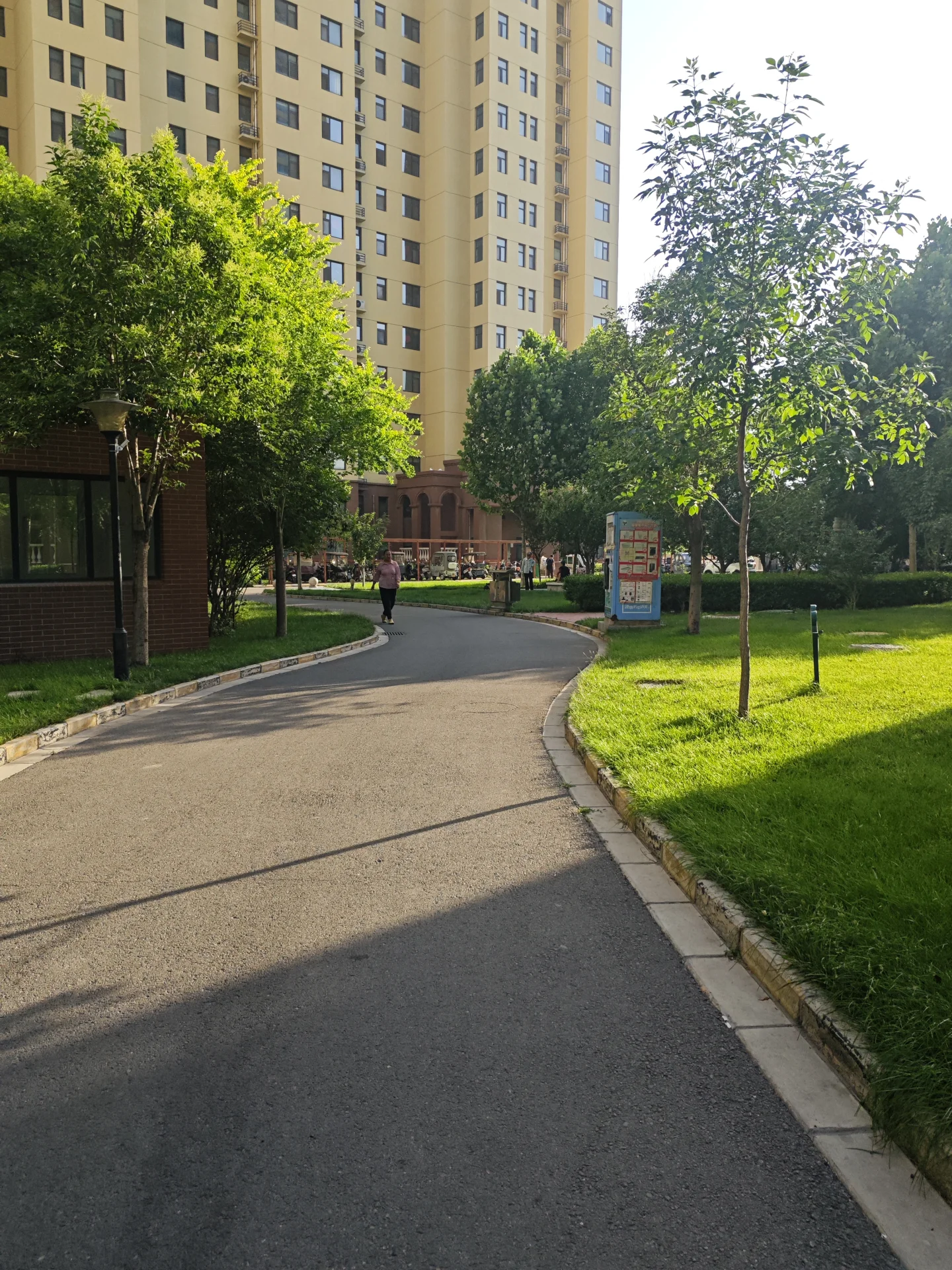 大楼街景，现代装饰风格，街道两侧树木环绕，氛围宁静舒适，行人散步。
