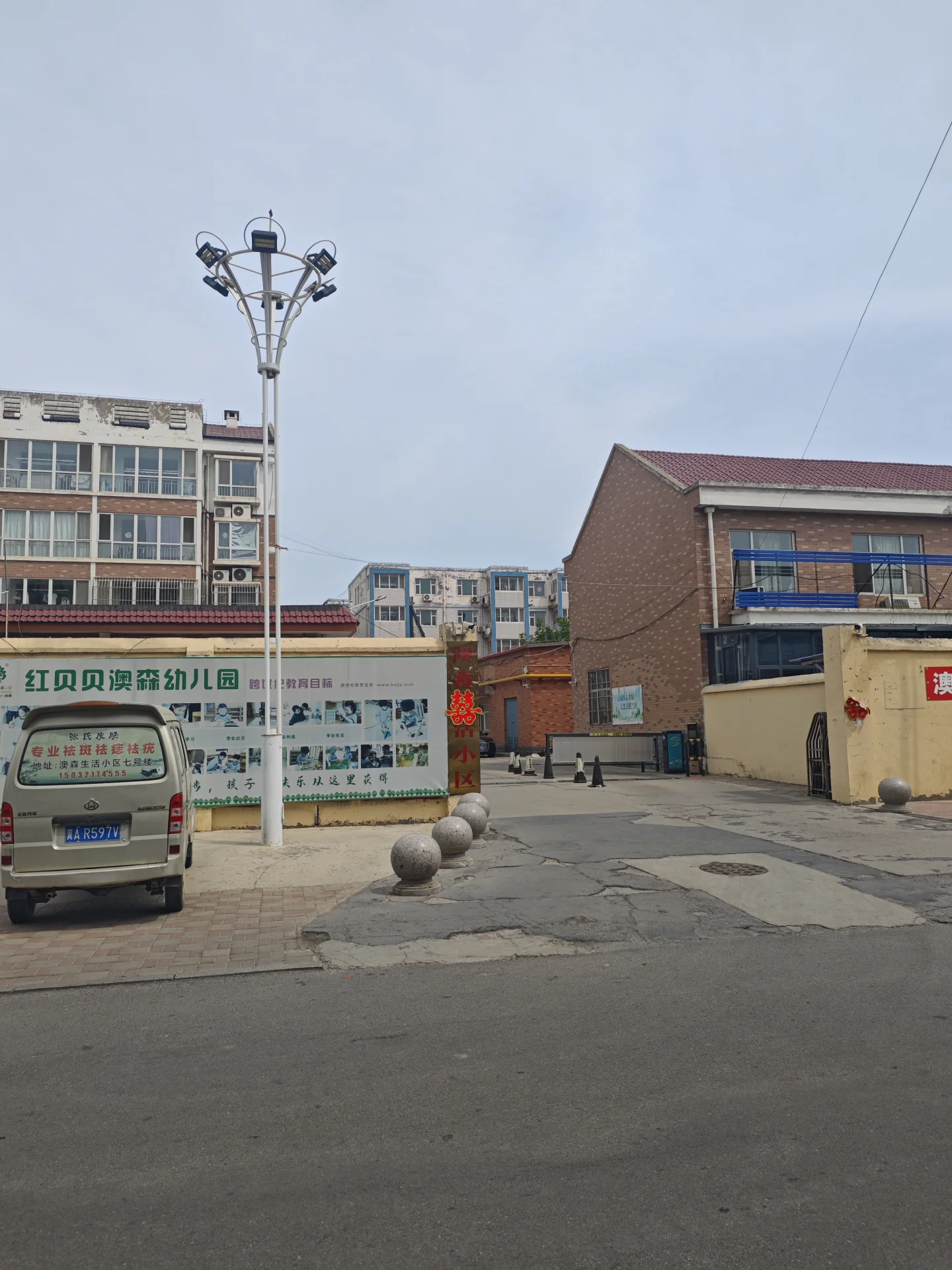 城市街道，停着一辆厢式货车，行人悠闲漫步，一人坐在建筑物前。背景有大型广告牌，增添都市气息。周围建筑风格多样，可能是老城区。整体氛围宁静，无交通拥堵。关键字:城市街道 厢式货车 行人 广告牌 老城区 宁静