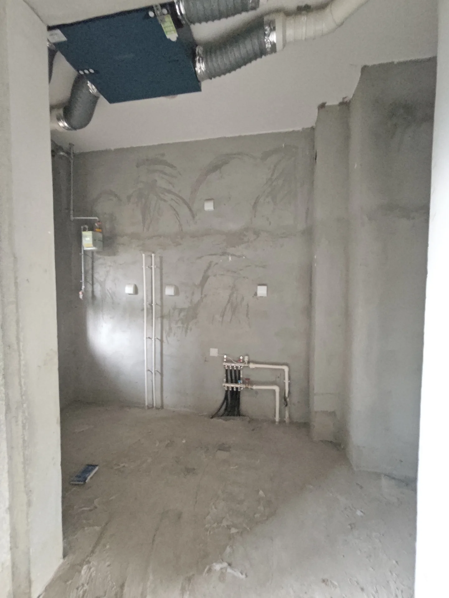 水泥墙和地板的房间，天花板悬挂着一根管道，显得正在施工或翻新。关键字:水泥墙 地板 管道 施工 翻新