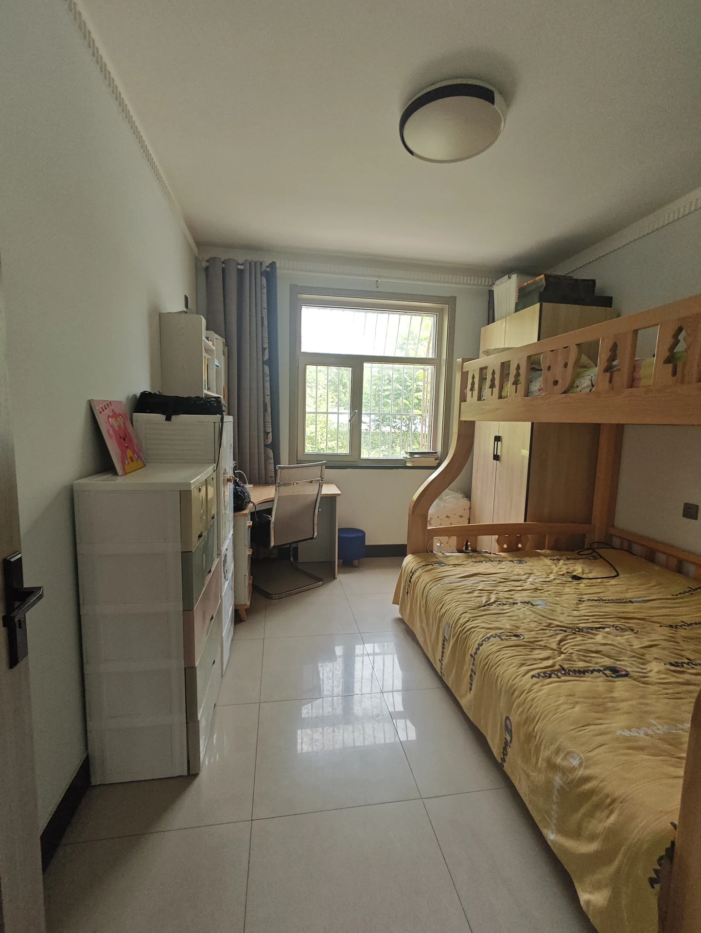 卧室采用白色调，两侧各有 beds，中间摆放 desk，窗户引入自然光，电视提供娱乐。整体氛围干净整洁，书本和杯子散落其间。关键字:卧室 白色调 beds desk 自然光 电视 干净整洁