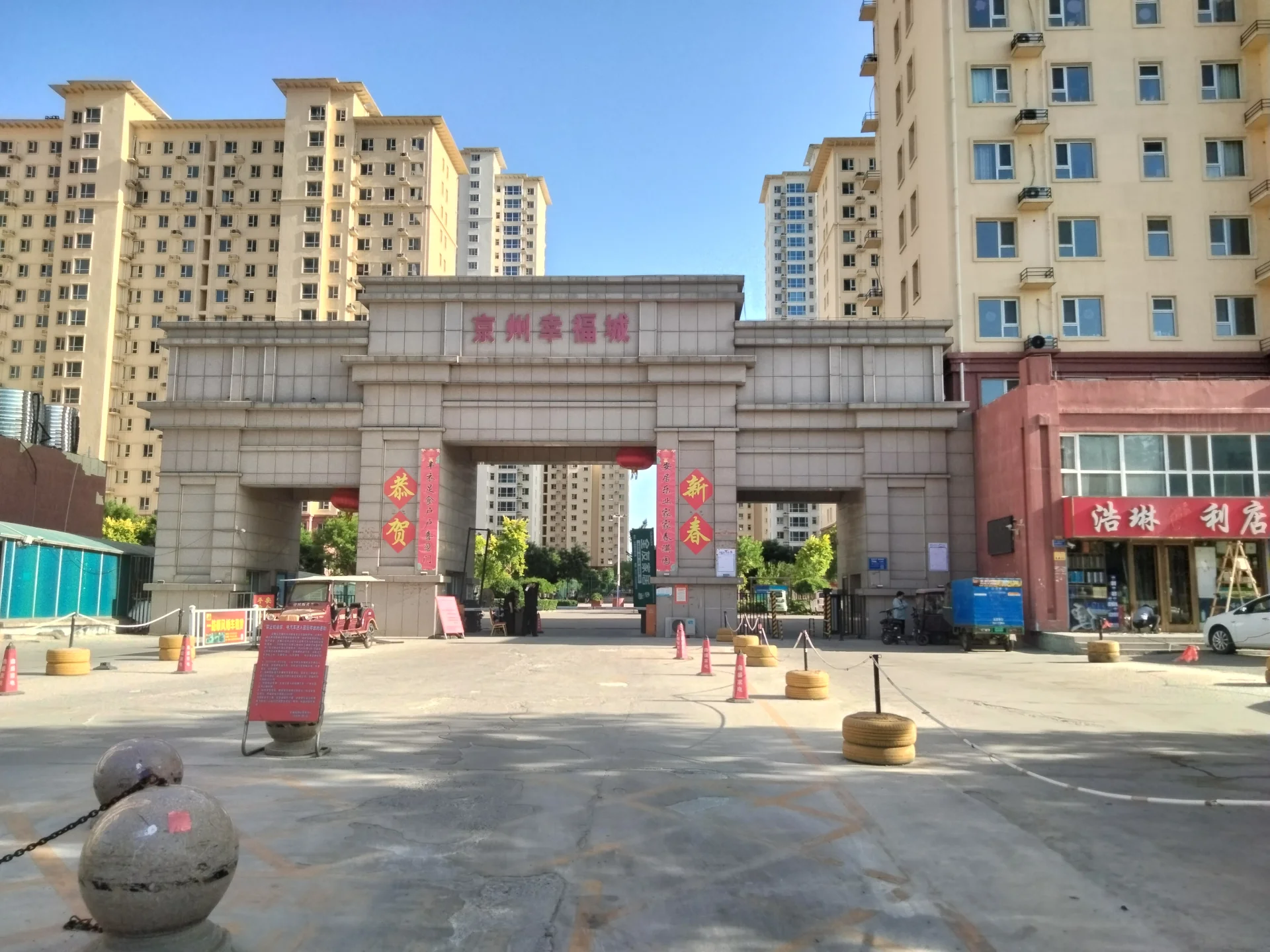 宽敞的石拱门中央，高楼环绕，充满活力的亚洲城市景象。关键字:石拱门 高楼 亚洲城市 繁忙氛围