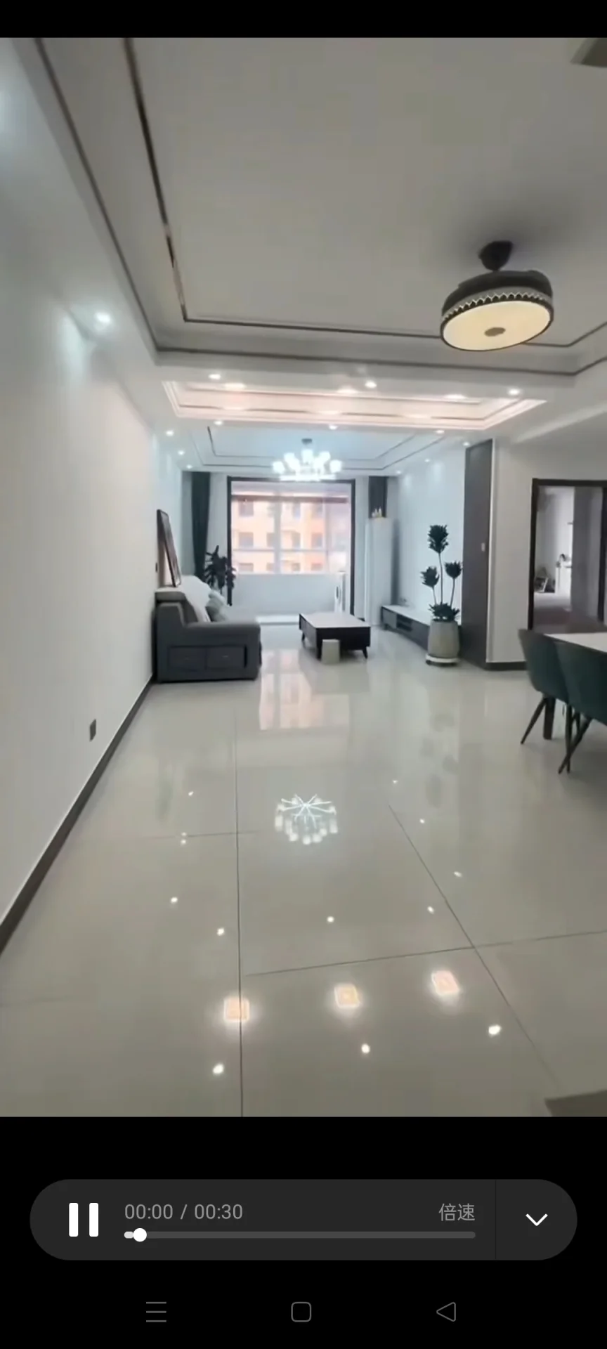 宽敞明亮的房间，白色瓷砖地面，中央有一把椅子，右侧稍远处有一把椅子，左侧有沙发。三盆绿植点缀其间，为空间增添生机。目前房间内无人物。关键字:宽敞 明亮 白色瓷砖 椅子 沙发 绿植