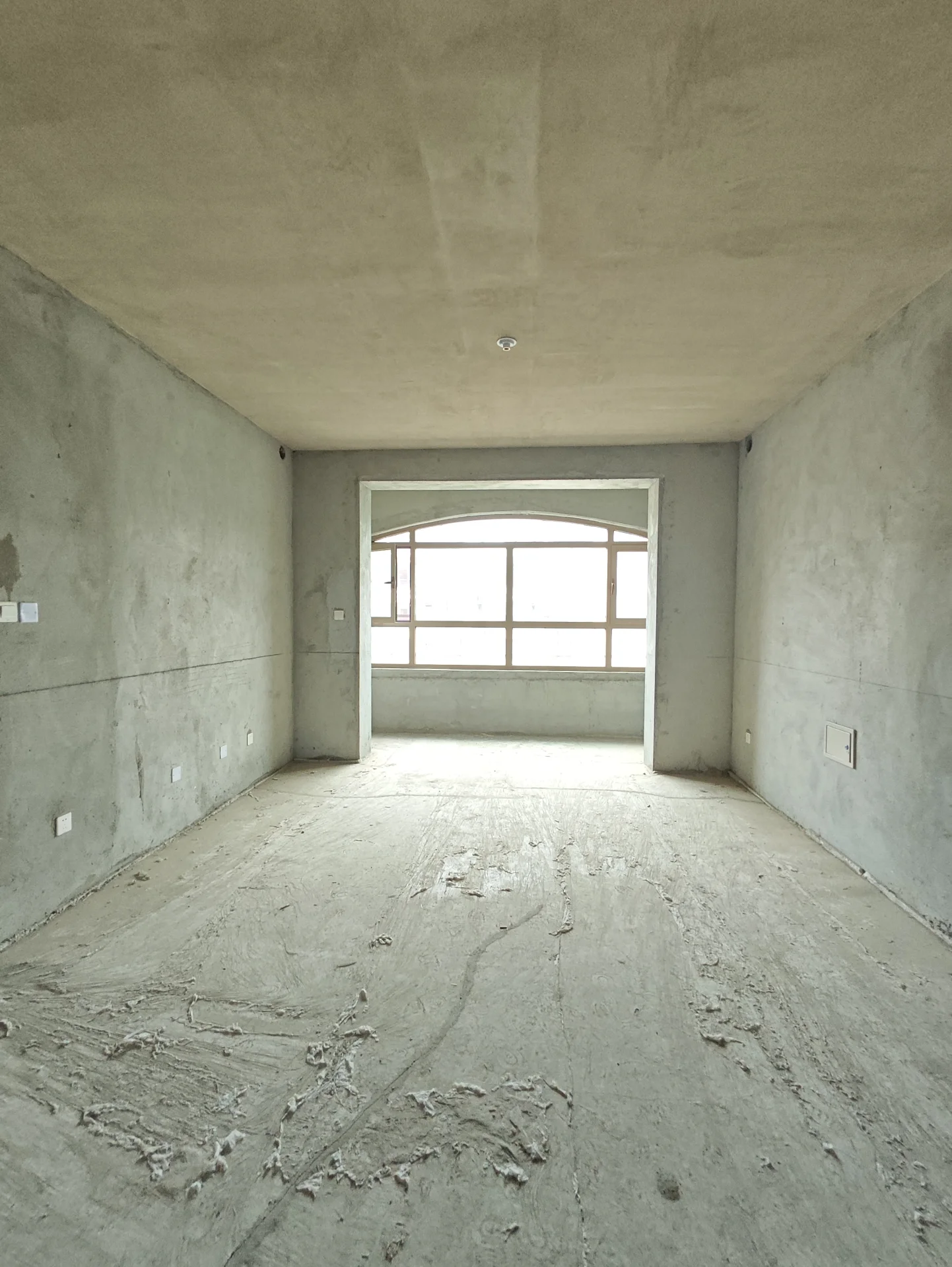 宽敞明亮的空房间，混凝土地面，高 ceilings，大窗户。现代简约风格，安静未被占用，略显冷清。关键字:空房间 混凝土地面 高 ceilings 大窗户 现代简约风格