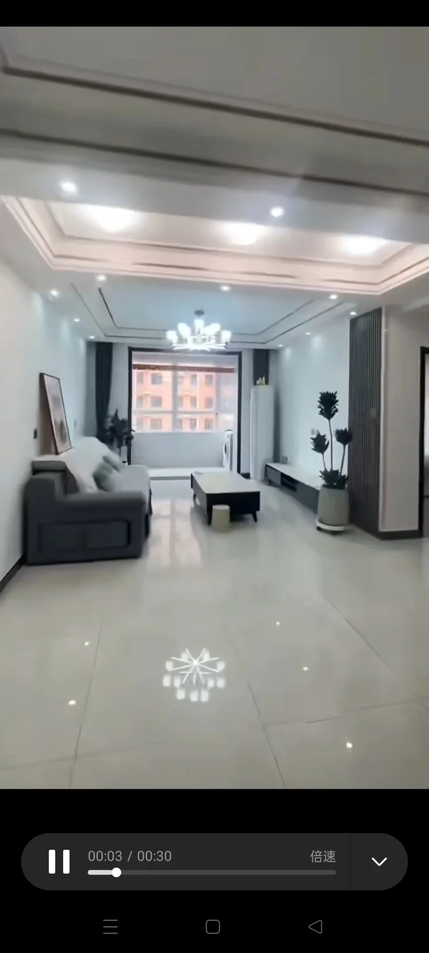 宽敞的客厅，大窗户让自然光充足，沙发靠窗而置，旁边是咖啡桌，一盆植物增添绿意，墙上挂有电视，提供娱乐。关键字:宽敞客厅 大窗户 自然光 沙发 咖啡桌 绿植 电视