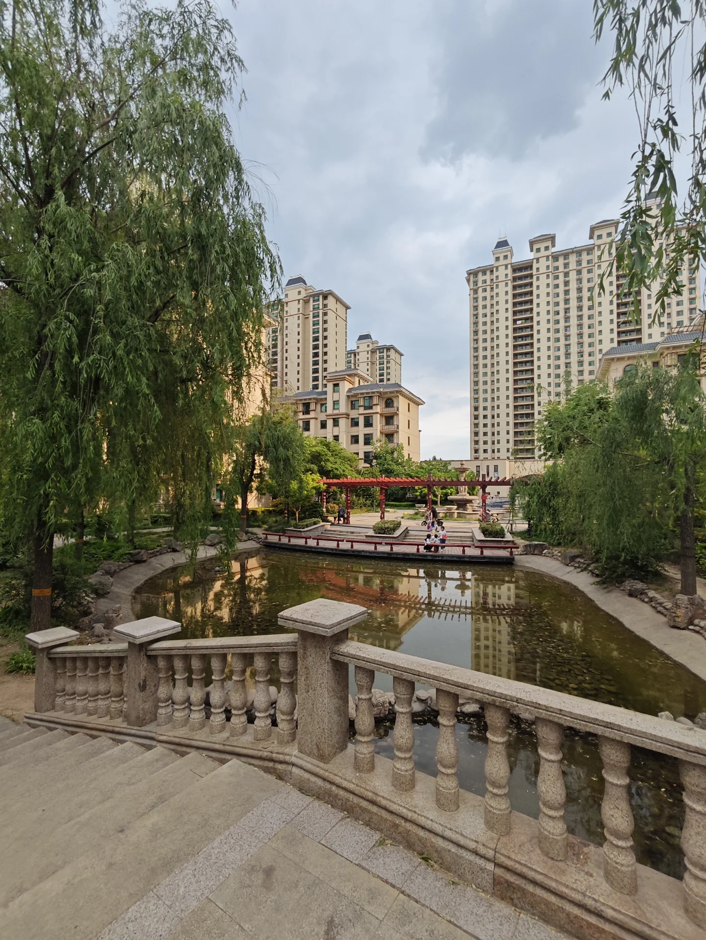河穿城而过，小船悠闲，绿树环绕，建筑融合现代与传统，宁静优雅，桥梁增添魅力。关键字:城市河流 小船 绿树 现代建筑 传统建筑 宁静氛围 桥梁